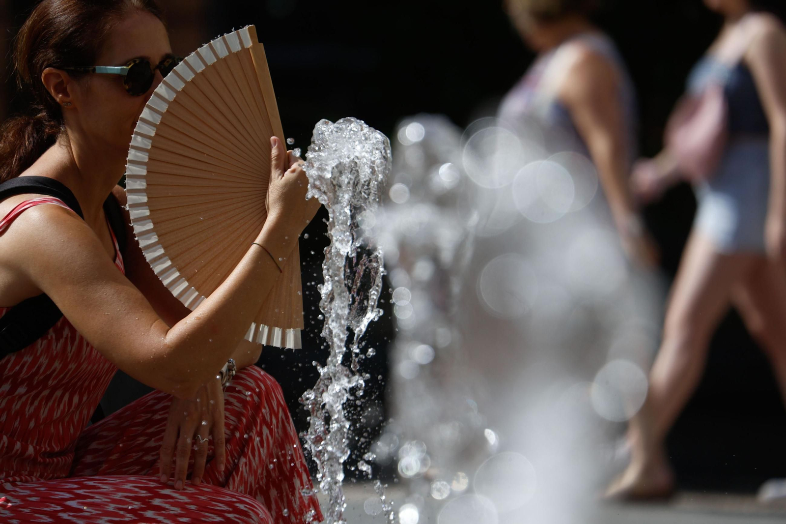 Mujer expuesta al sol mientras se abanica