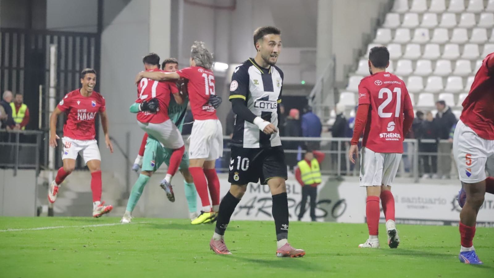 Cascajo lamenta el penalti fallado en el minuto 100 mientras el Dos Hermanas lo celebra
