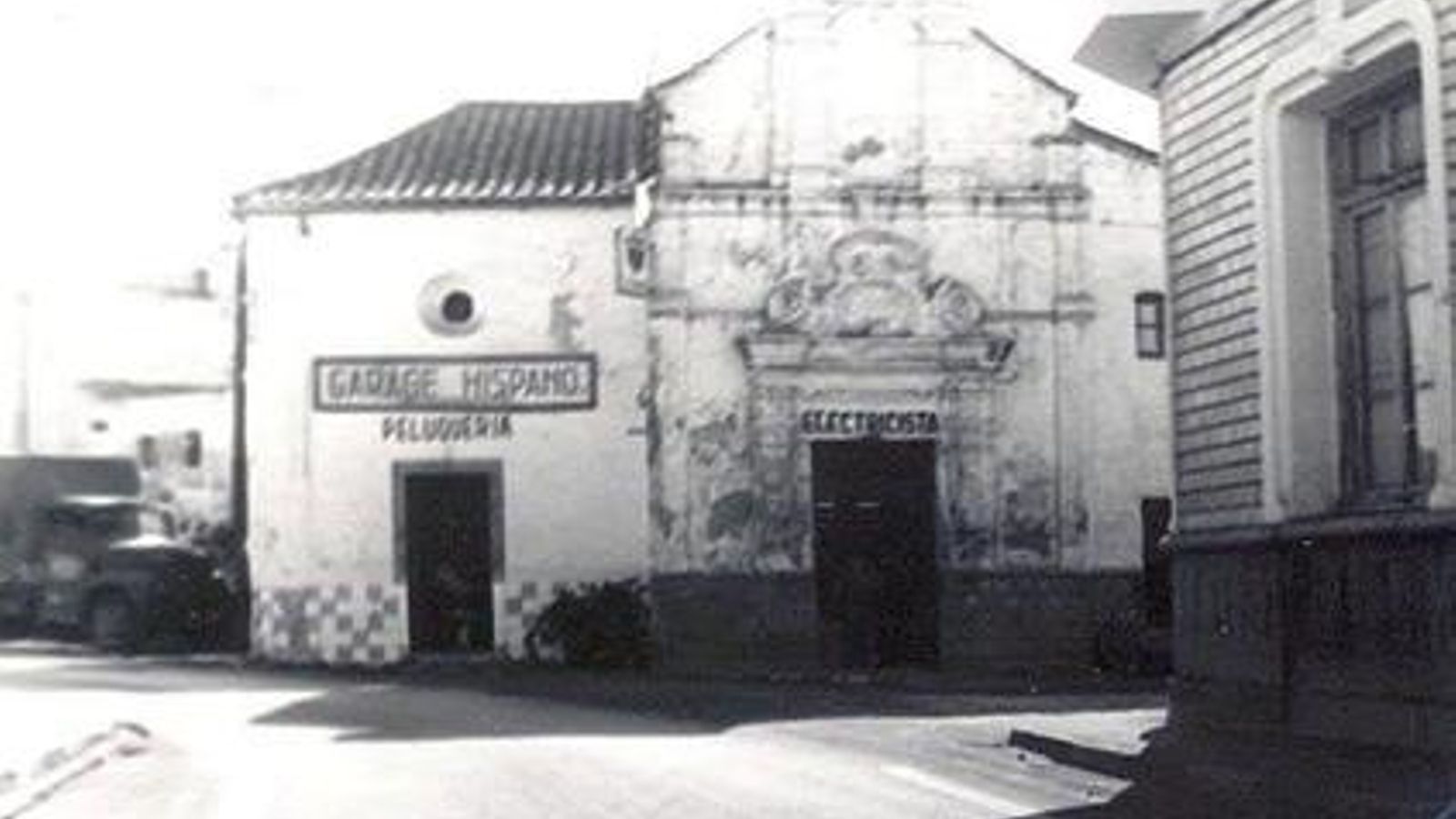 La capilla, en su fase de explotación para diversos servicios: peluquería, electricidad del automóvil, reparación de neumáticos.  A la izquierda y también tapada por la casa, la entrada al importante Garaje Hispano.