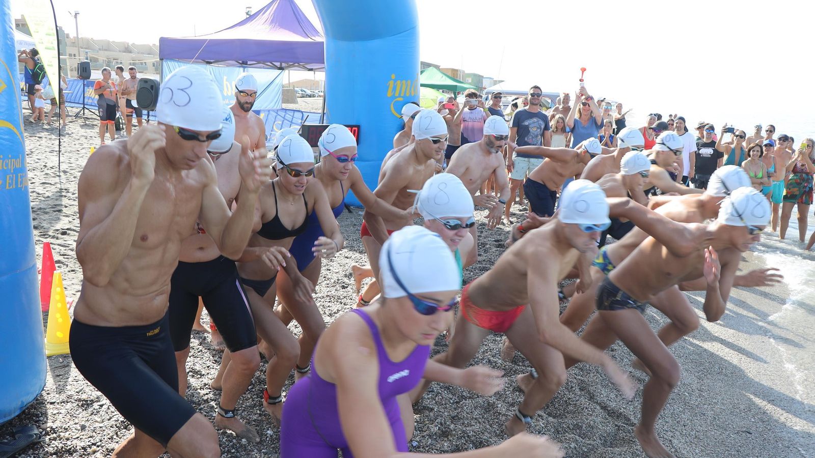 Los participantes toman la salida de la prueba en la playa de Balerma.