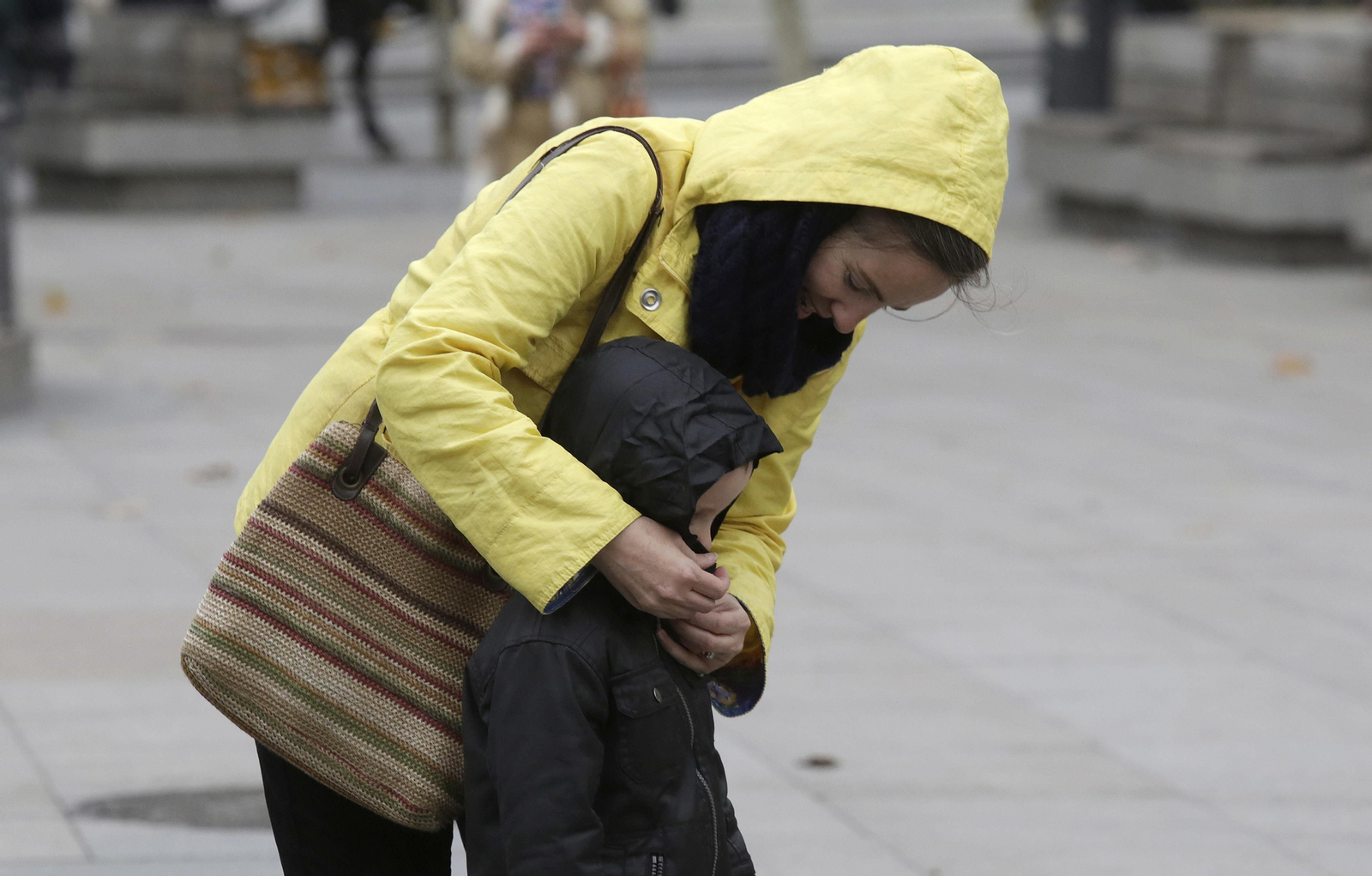 Una madre abriga a su hijo un día de frío en Sevilla.