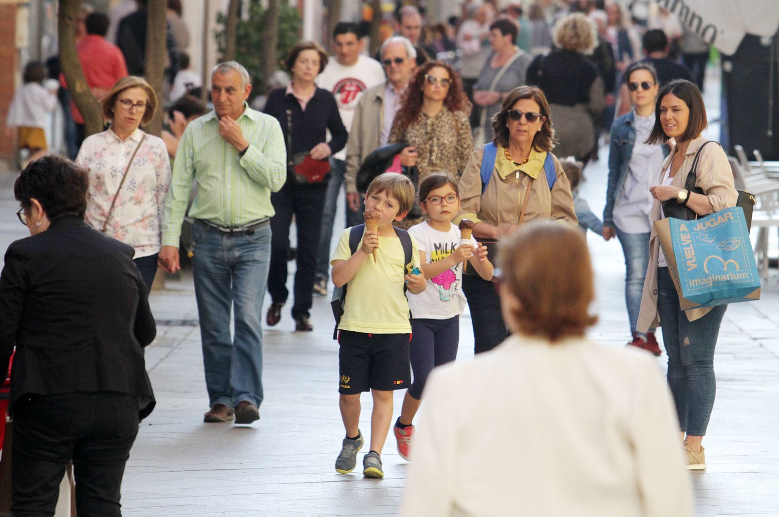 Ciudadanos de diferentes edades transitan por la principal arteria comercial de Huelva.