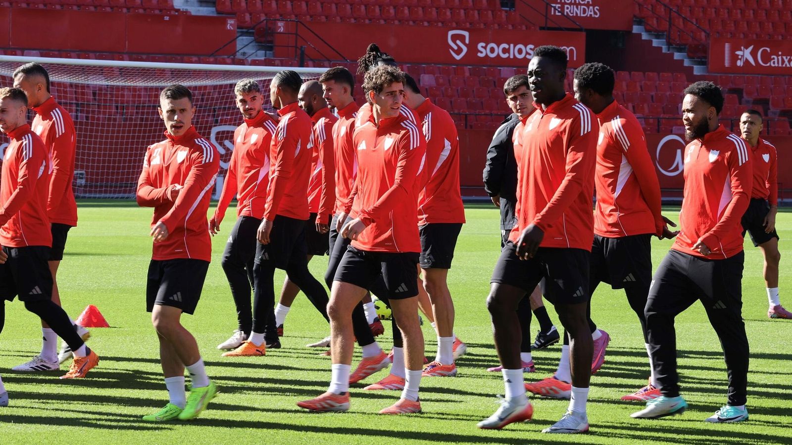 Alfon, Manu Bueno y Akor Adams caminan ante un grupo en un entrenamiento.