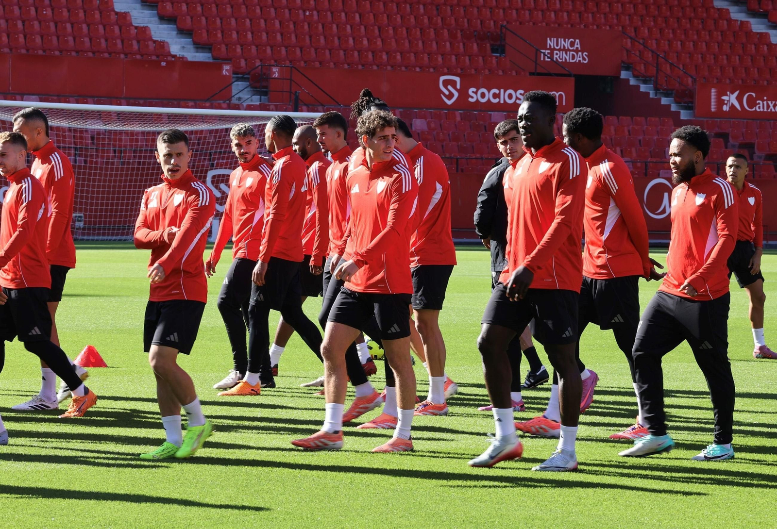 Alfon, Manu Bueno y Akor Adams caminan ante un grupo en un entrenamiento.