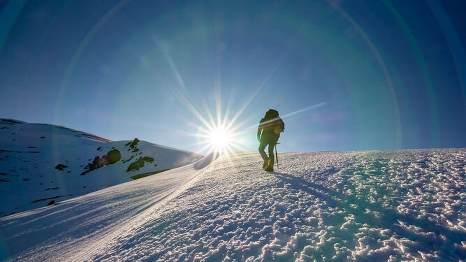 Una montañera hace cumbre en un pico