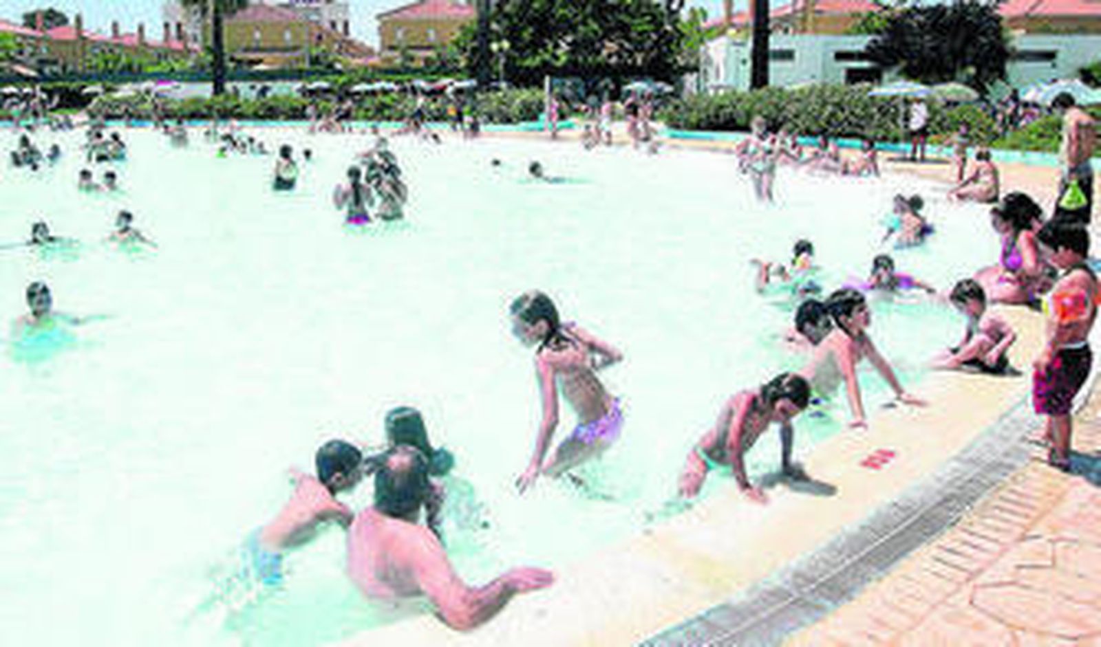 Niños bañándose en una piscina.