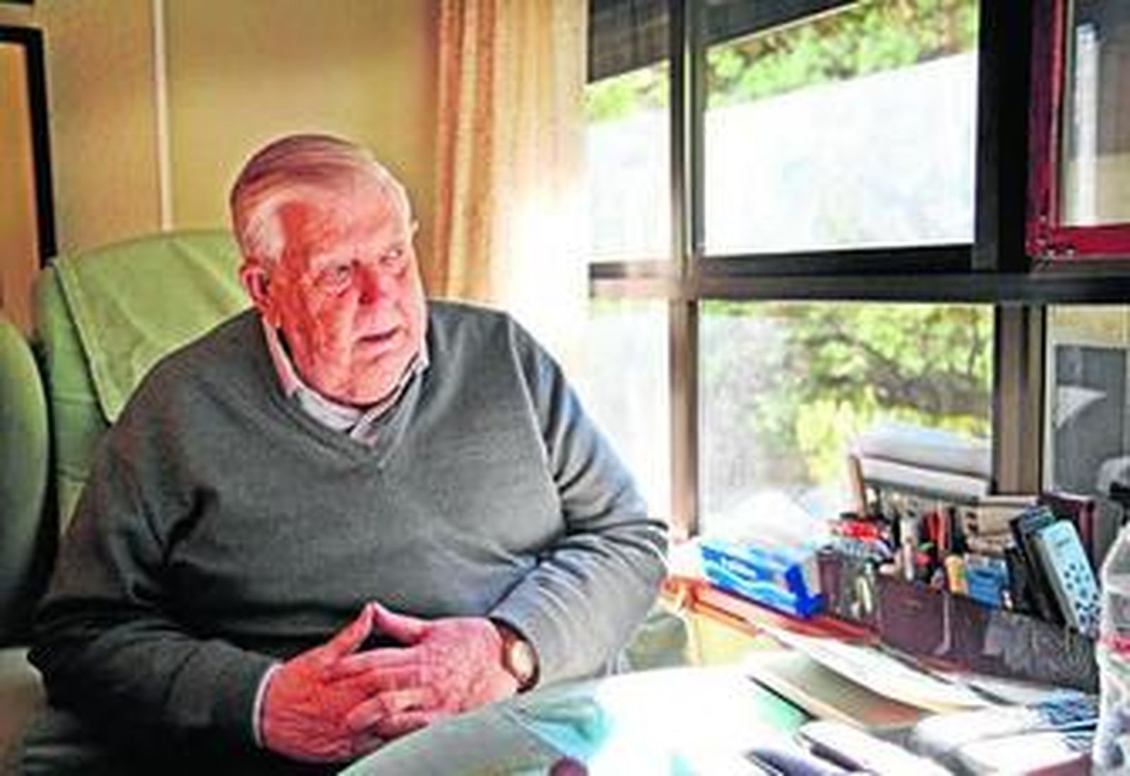 Miguel observa, pensativo, a través de las ventanas de su hogar sentado en su sillón favorito.
