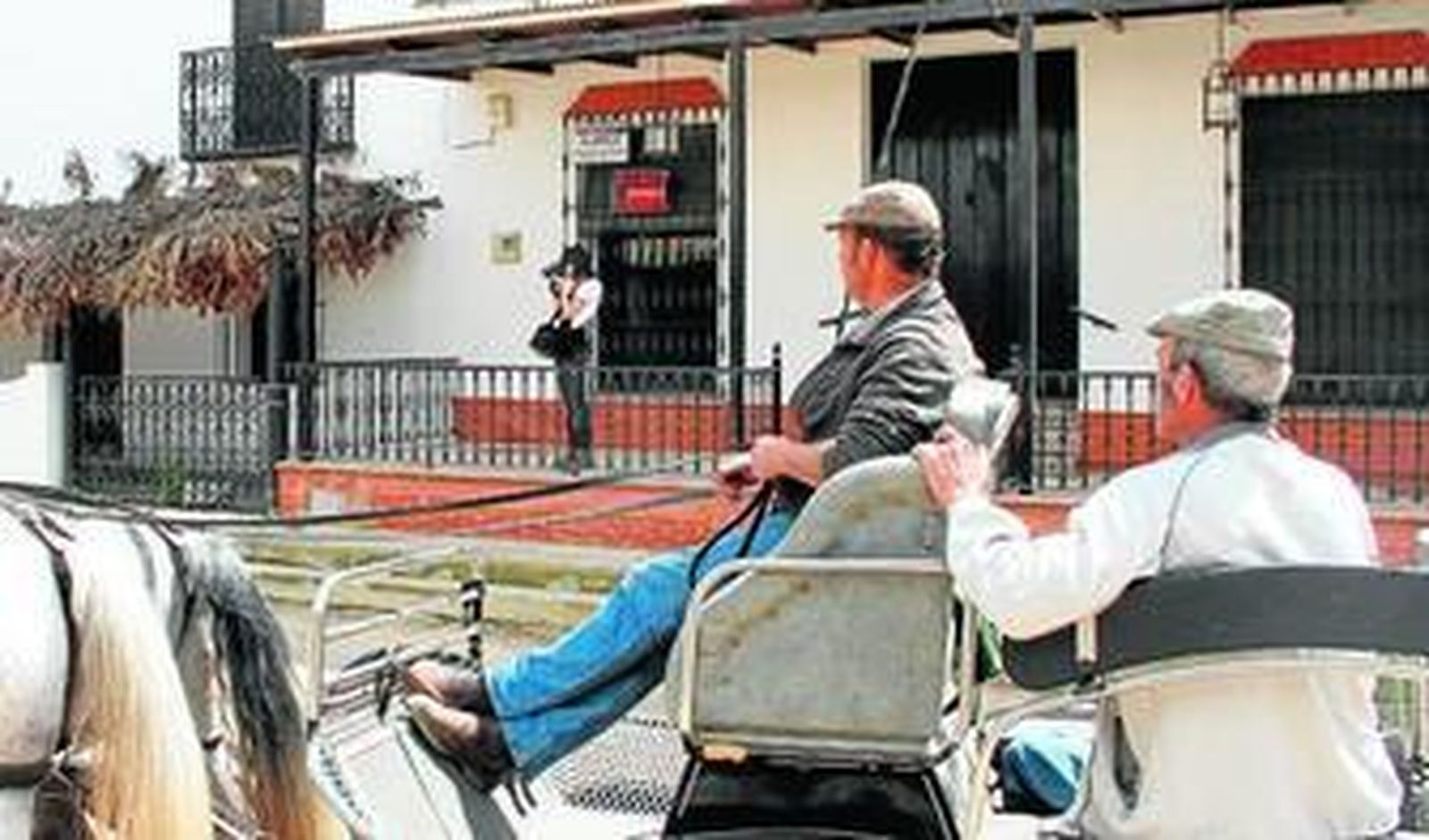 Una turista saca fotos con su cámara desde el porche de una casa el alquiler.