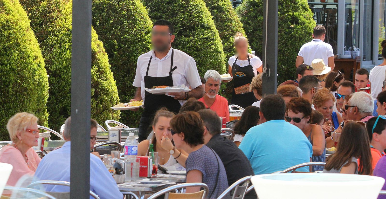 Varios camareros atienden en una terraza onubense.