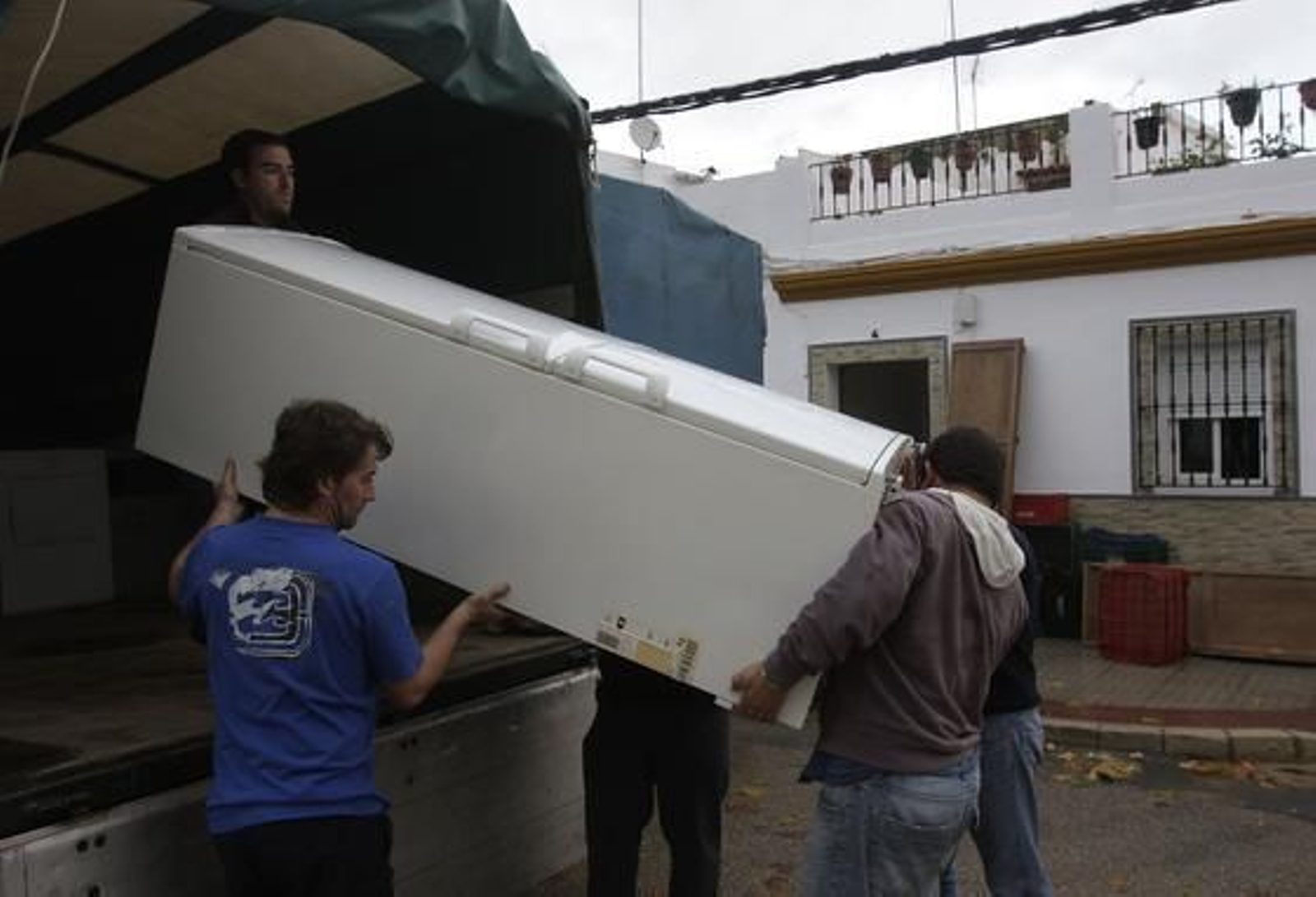 Los vecinos de Lora del Río intentan salvar algunos electrodomésticos de las inundaciones. 

Foto: José Ángel García