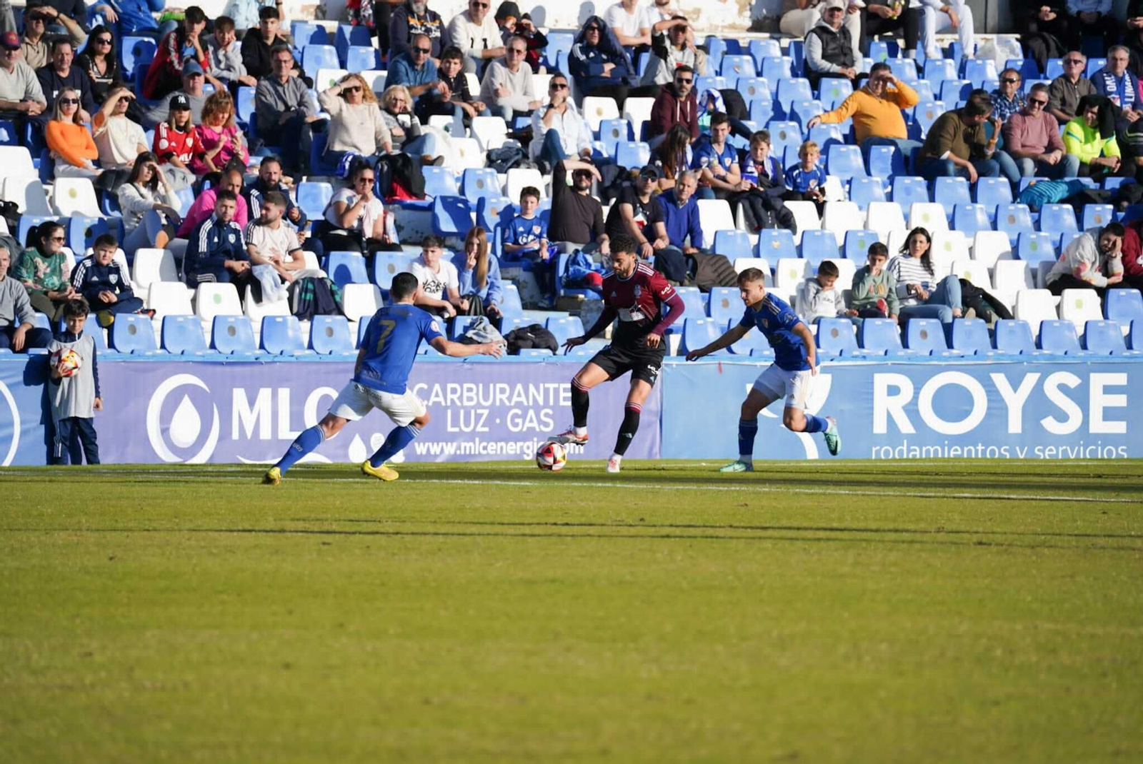 Jugadores del Linares presionan a Luis Alcalde, que controla el balón.