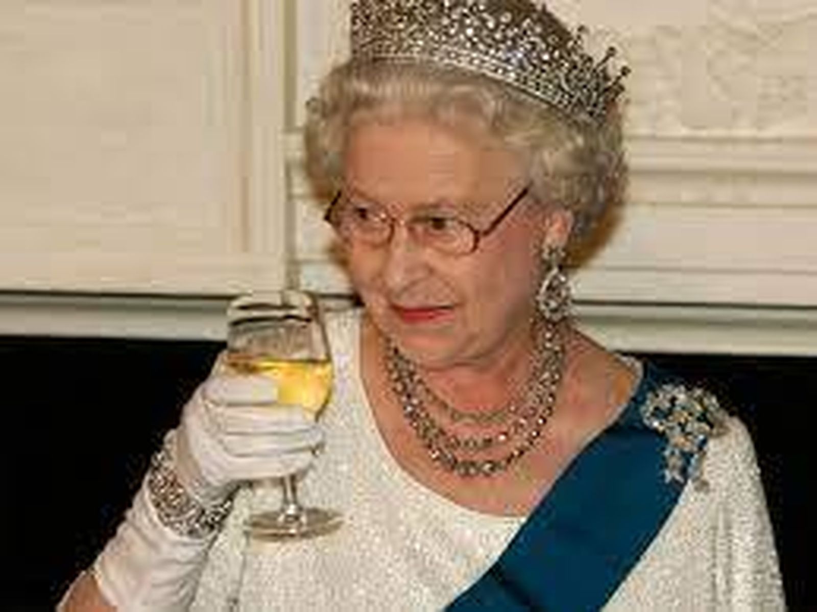La Reina Isabel brindando con una copa de vino.