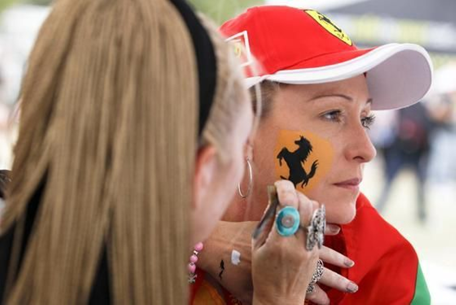 Dos chicas se pintan con el símbolo de Ferrari. (FOTOS: AFP/Reuters/EFE)