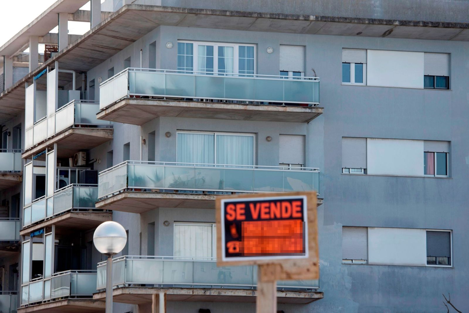 Imagen de un cartel de la venta de una vivienda en un bloque de pisos