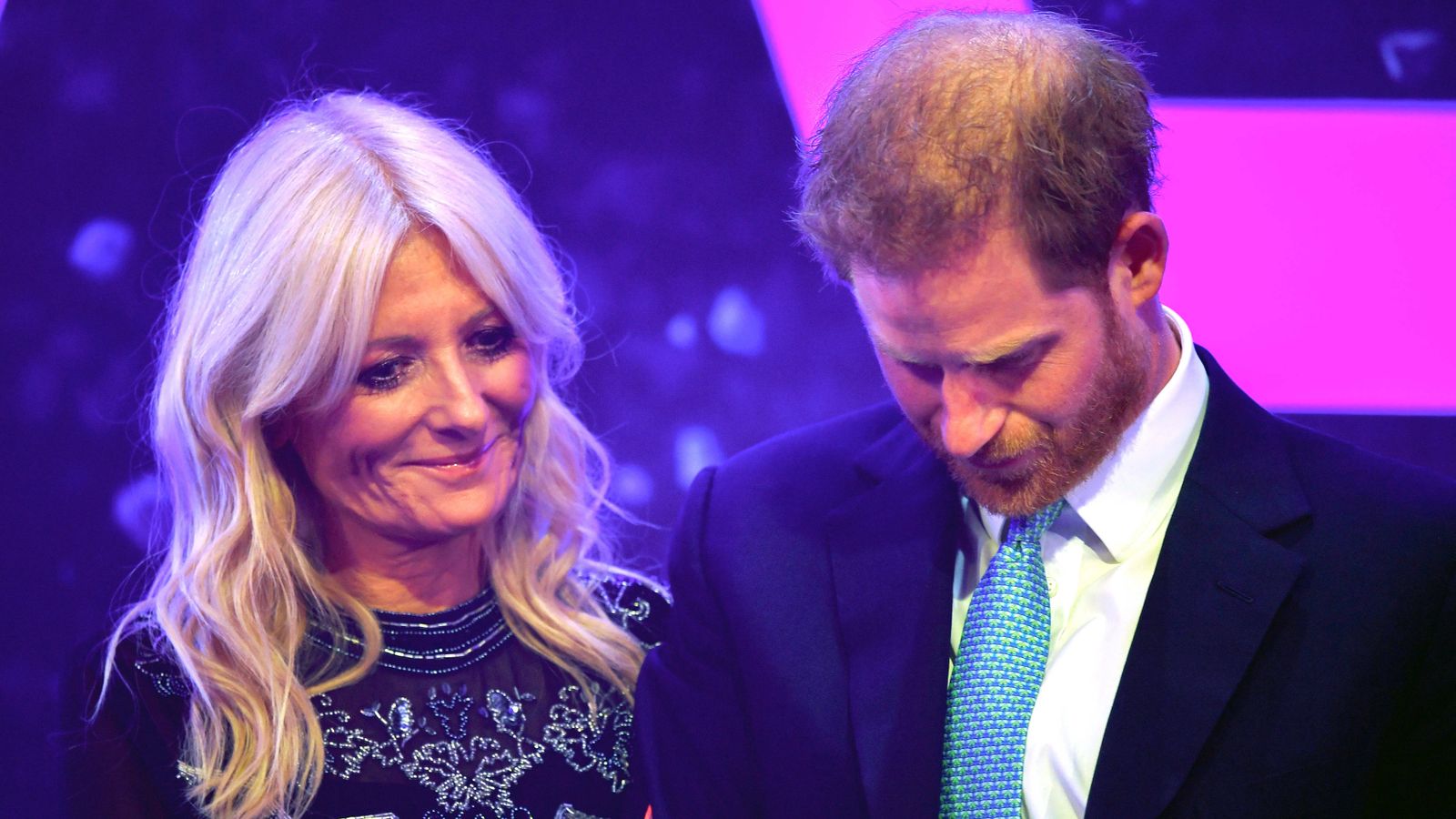 El príncipe Enrique, junto a la presentadora del acto.