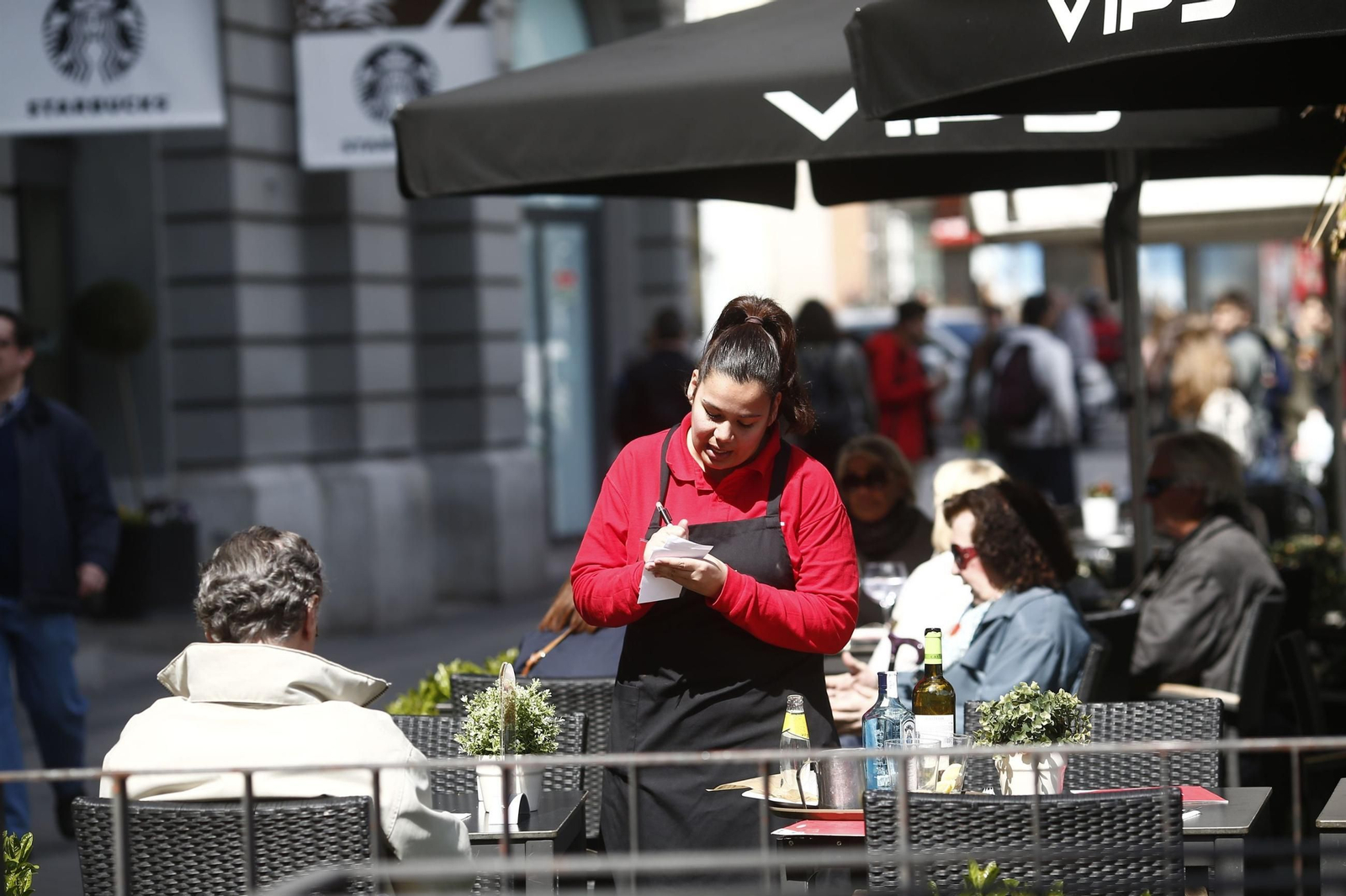Una camarera atiende a un cliente Una camarera atiende a un cliente
