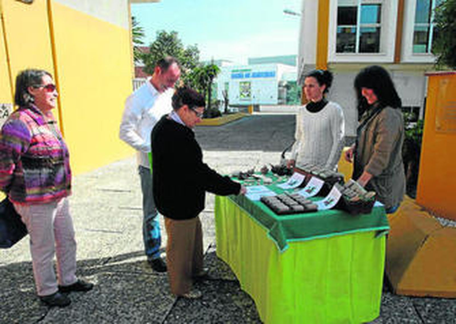 Dos alumnas de Entre dos algas presentan a varios clientes los jabones que elaboran en el curso.