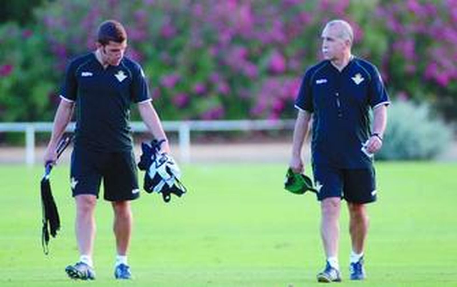 Tony Tapia, que acarrea varios petos de entrenamiento, junto a su padre en la sesión vespertina de ayer.