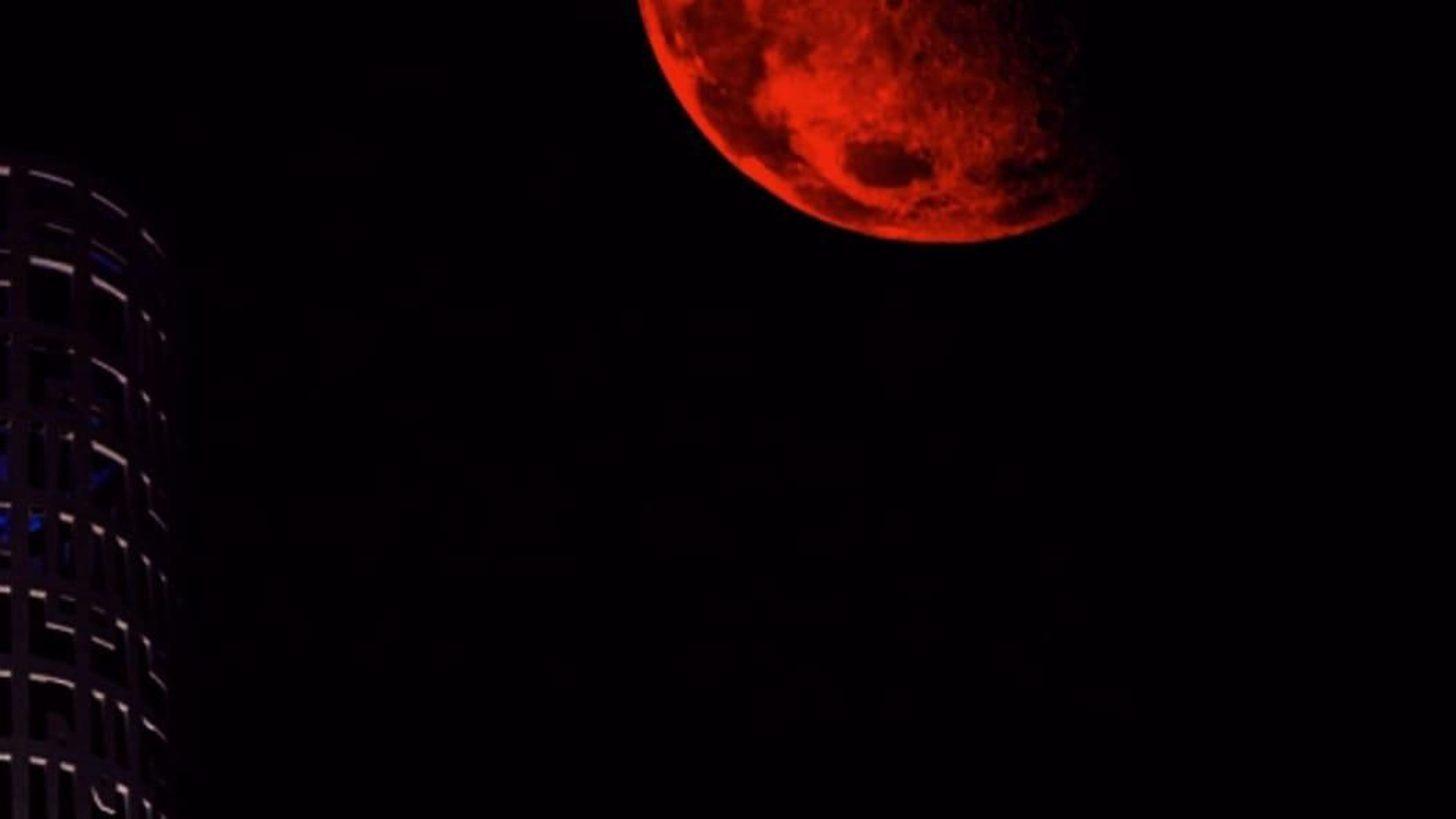 La Luna de Sangre, fotografiada con un filtro rojo, junto a una de las Torres de Hércules, en Palmones (Los Barrios).