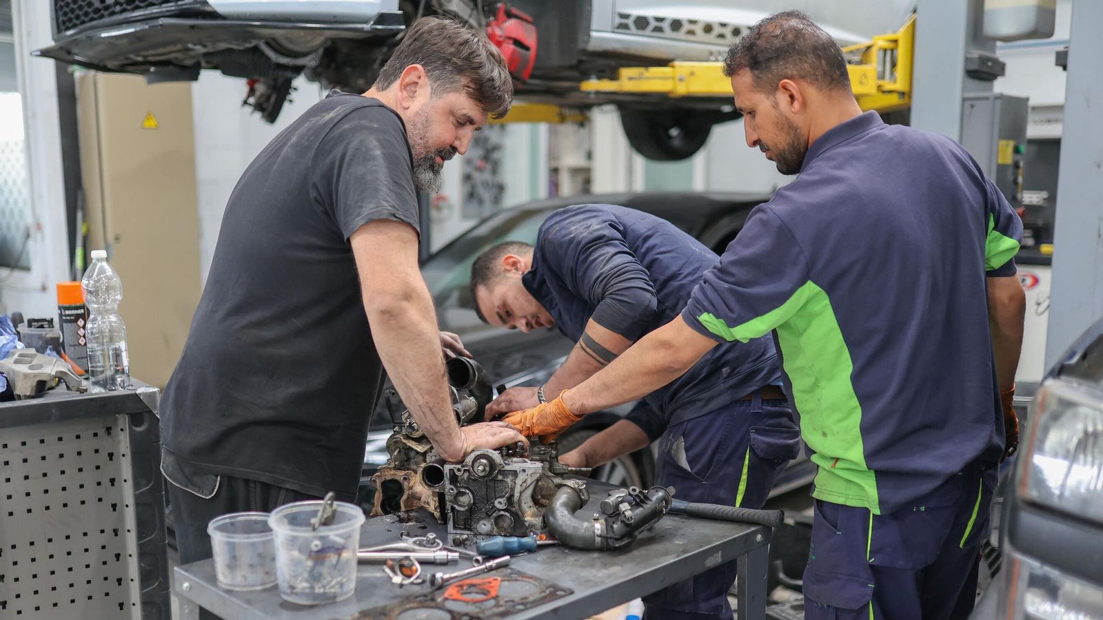 Mecánicos de Mulhacén Car Service reparan a mano una pieza