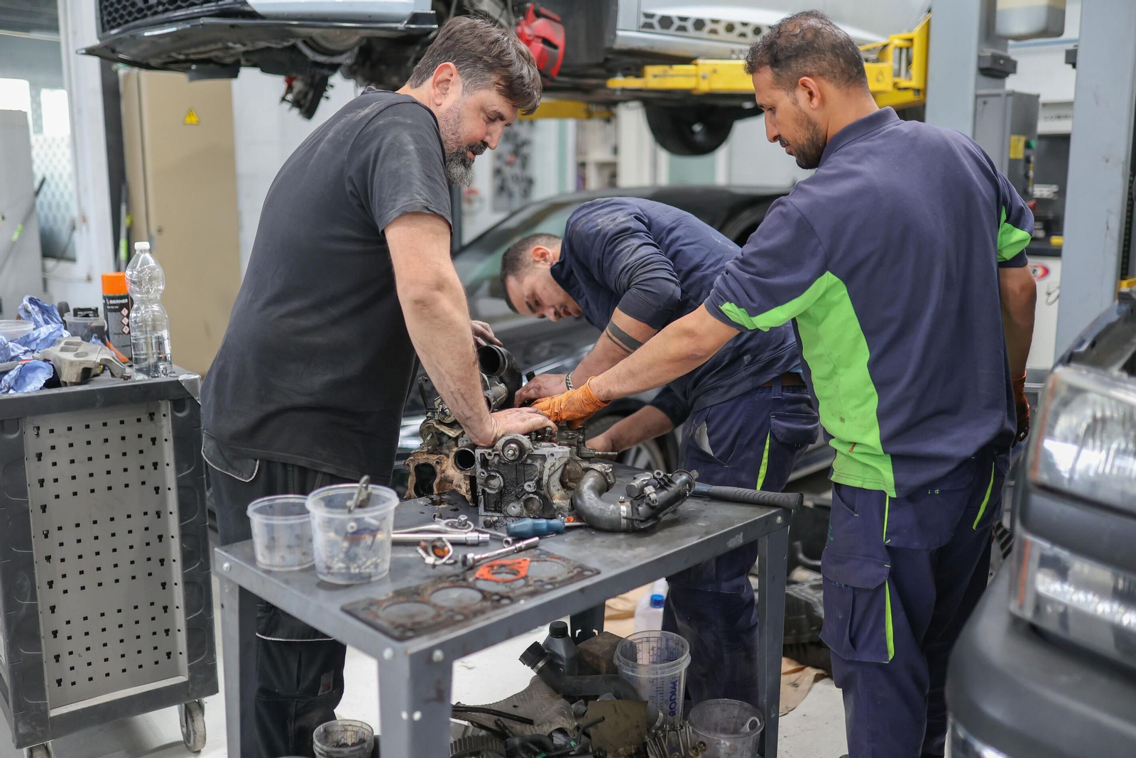 Mecánicos reparan a mano una pieza en un taller de Granada