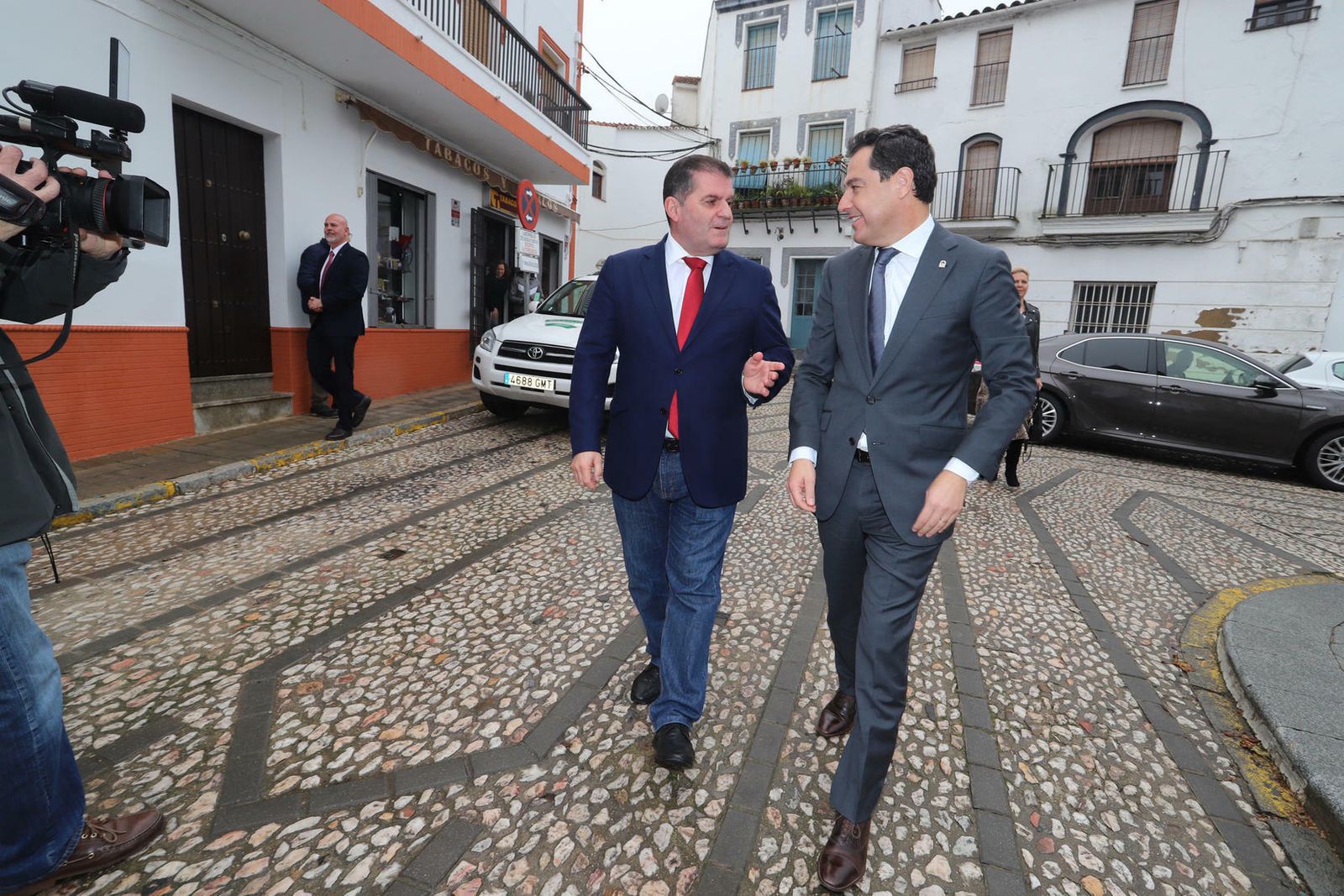 El alcalde de Jabugo, Gilberto Domínguez, recibe al presidente de la Junta de Andalucía, Juanma Moreno, a las puertas del Ayuntamiento.