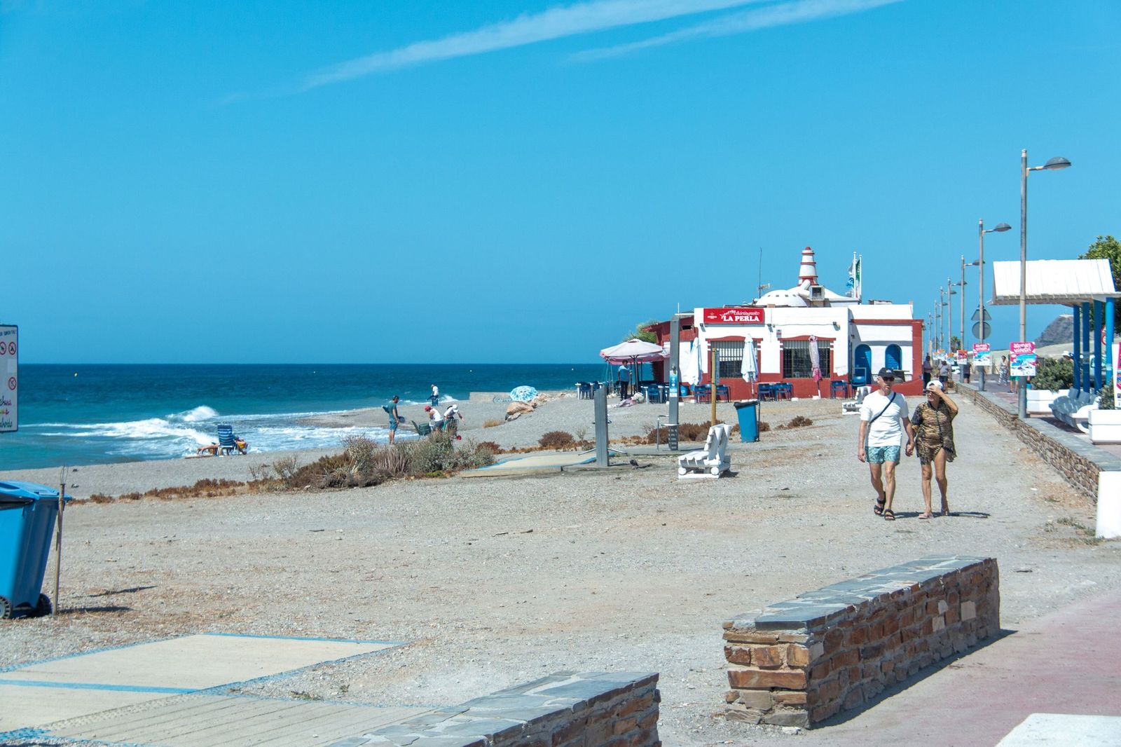 Dos personas pasean por la playa de La Perla