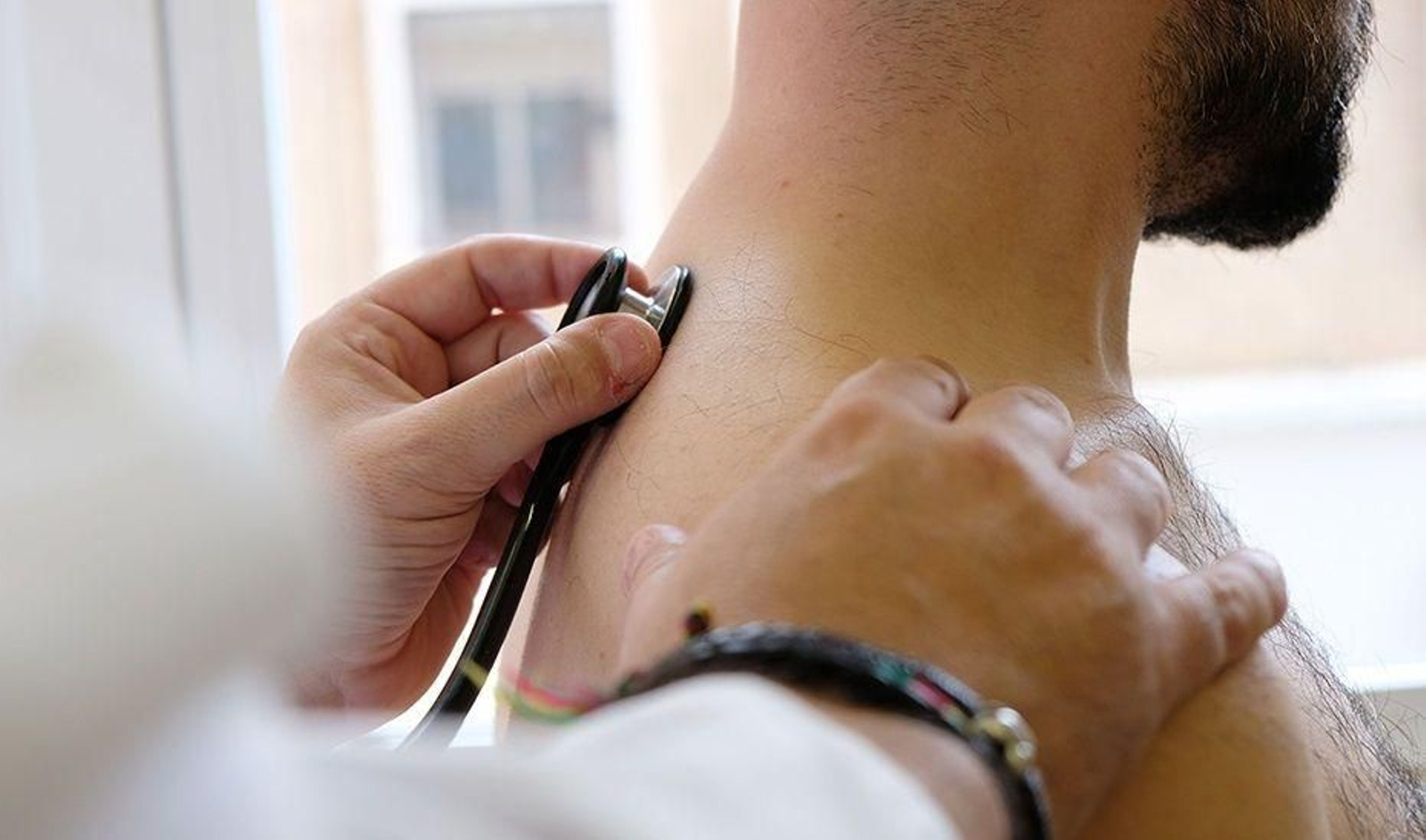 Un médico examina a un paciente con un fonendoscopio. Un médico examina a un paciente con un fonendoscopio.