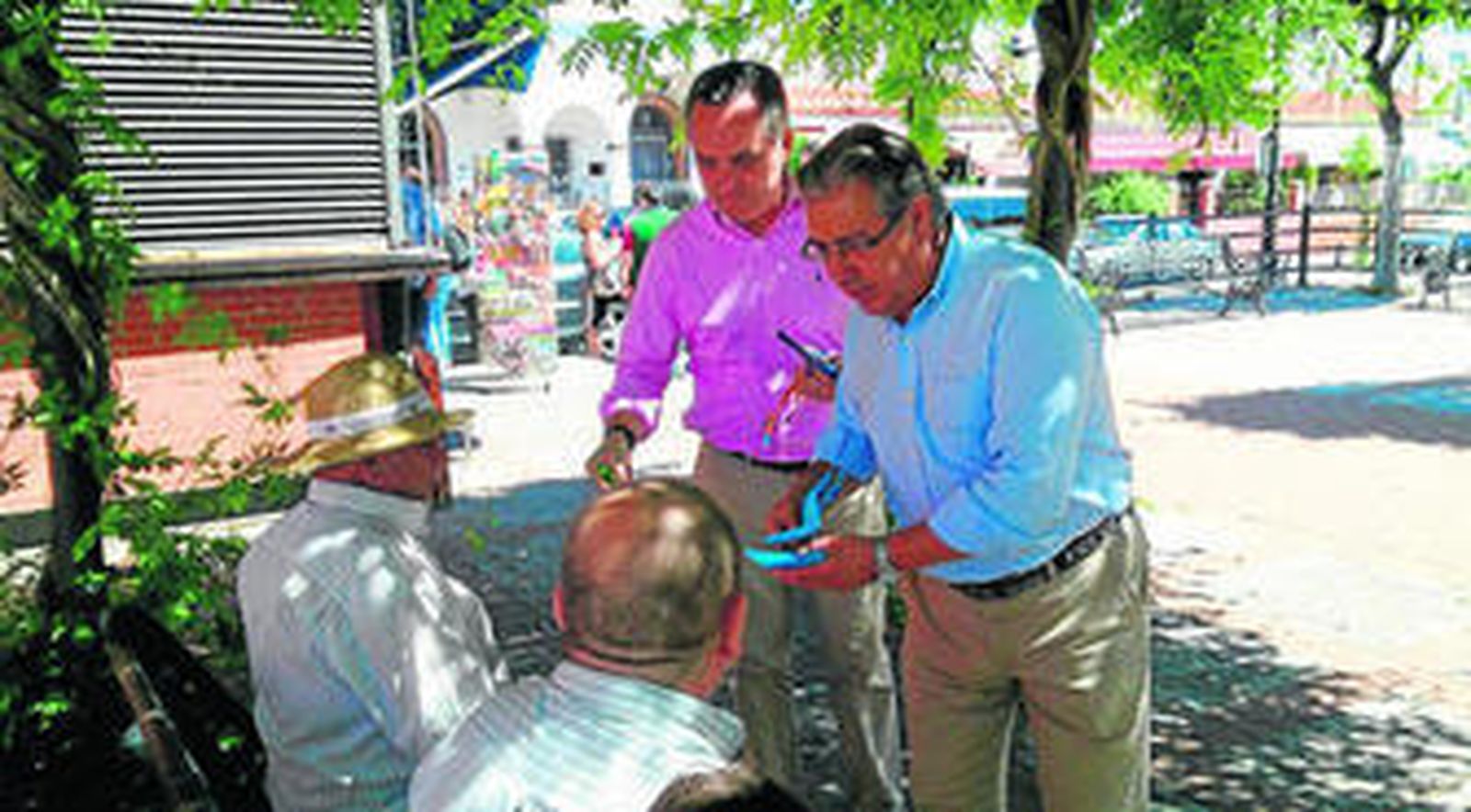 Zoido y Bueno entregan propaganda electoral a unos vecinos de Espartinas durante su paseo por el municipio aljarafeño.