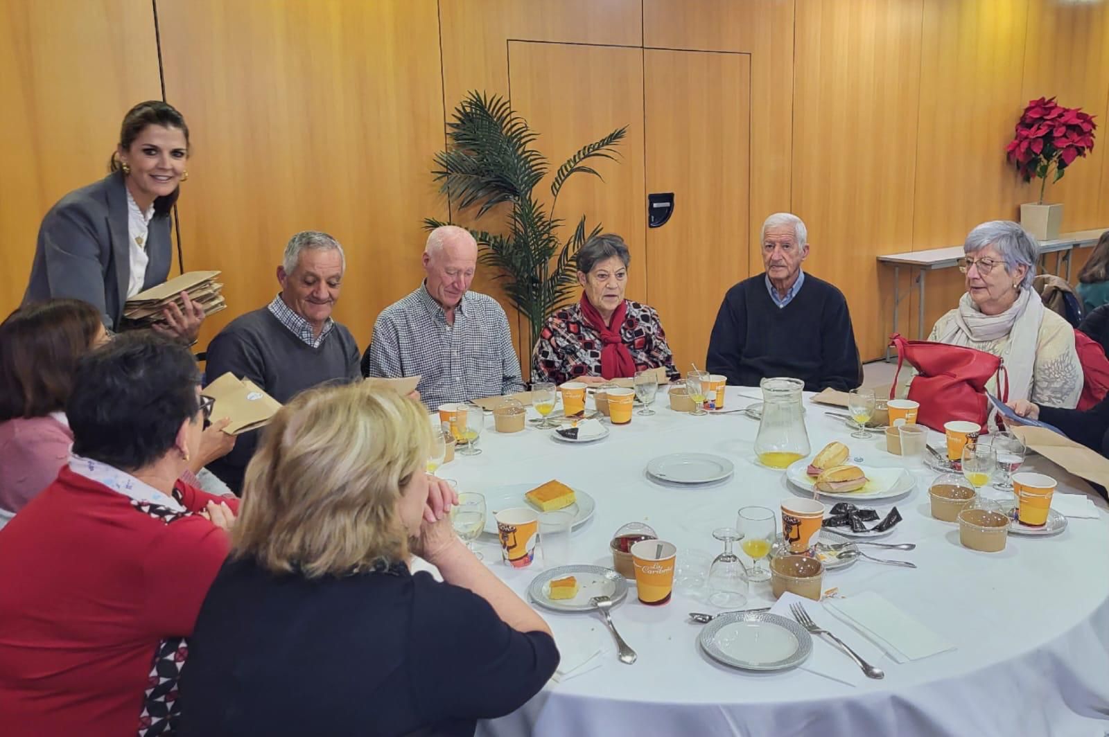 Delia Mira entrega una agenda a cada participante.