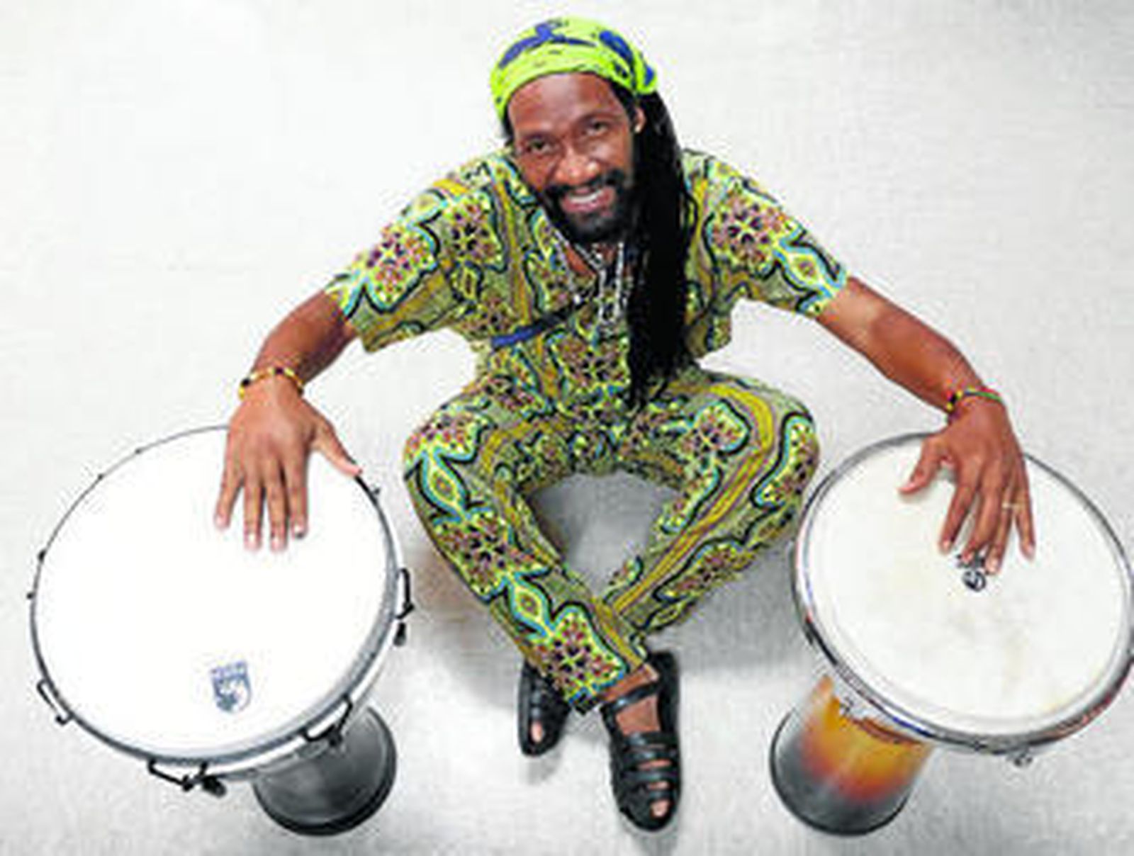 Kilema posa con dos instrumentos de percusión.