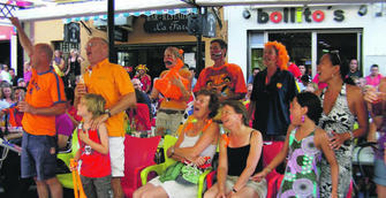 Un grupo de turistas en una terraza de Ronda, animando a su equipo.