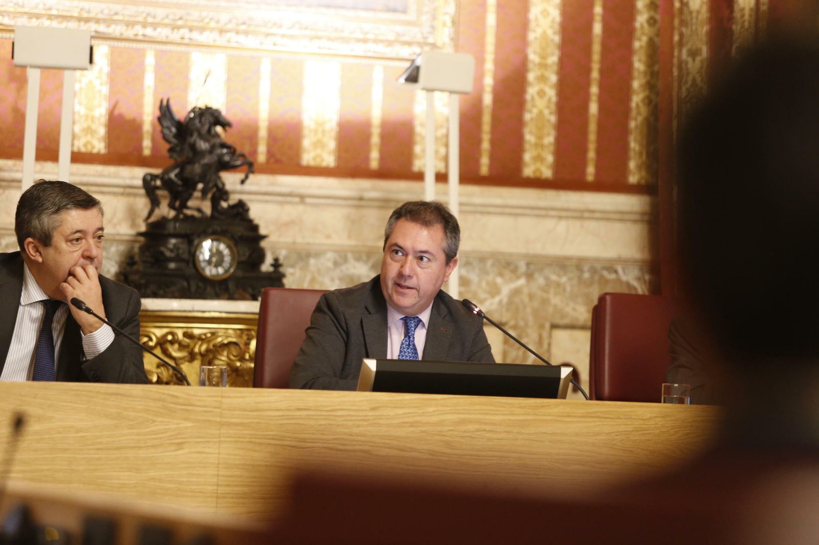 El alcalde, junto al secretario municipal, interviene en la sesión plenaria.