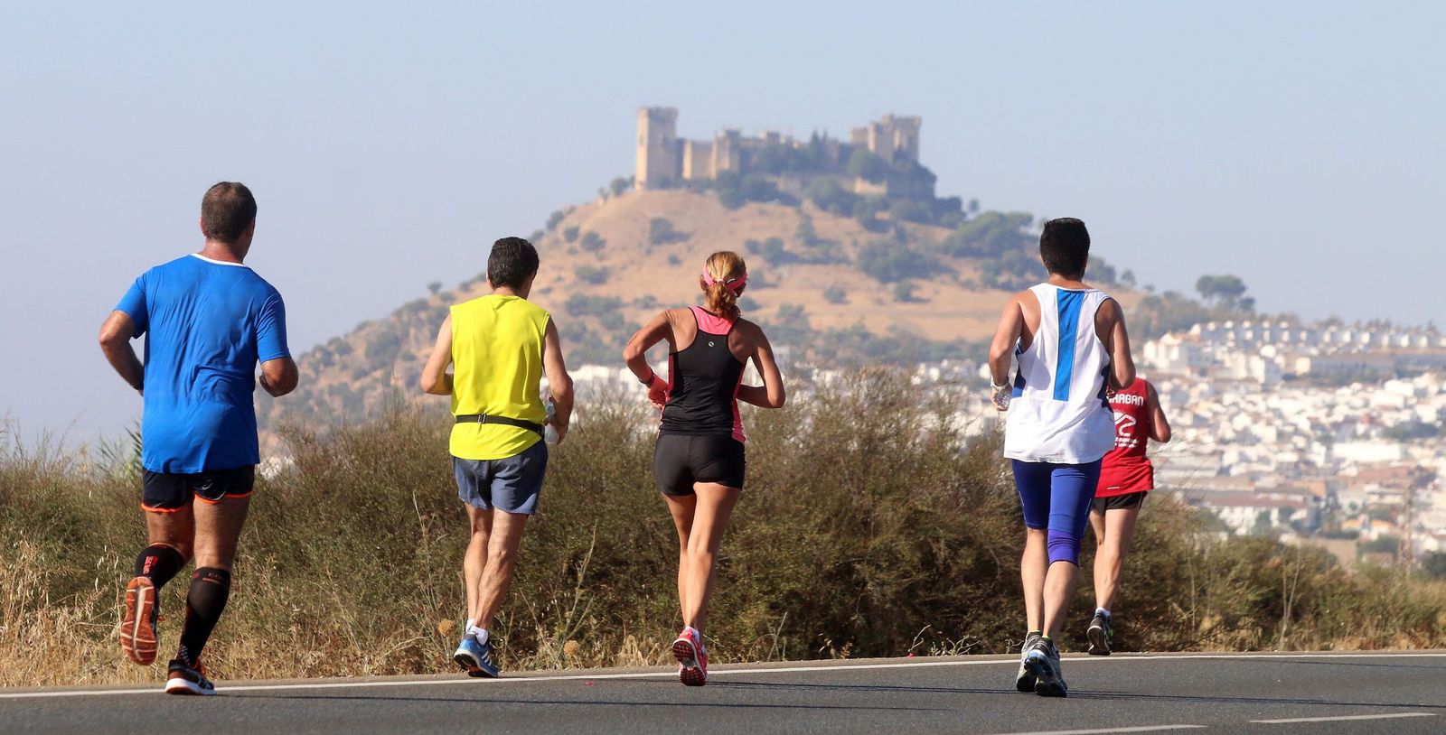 Varios corredores de la Media Maratón Córdoba-Almodóvar, con el emblemático castillo cuco al fondo.