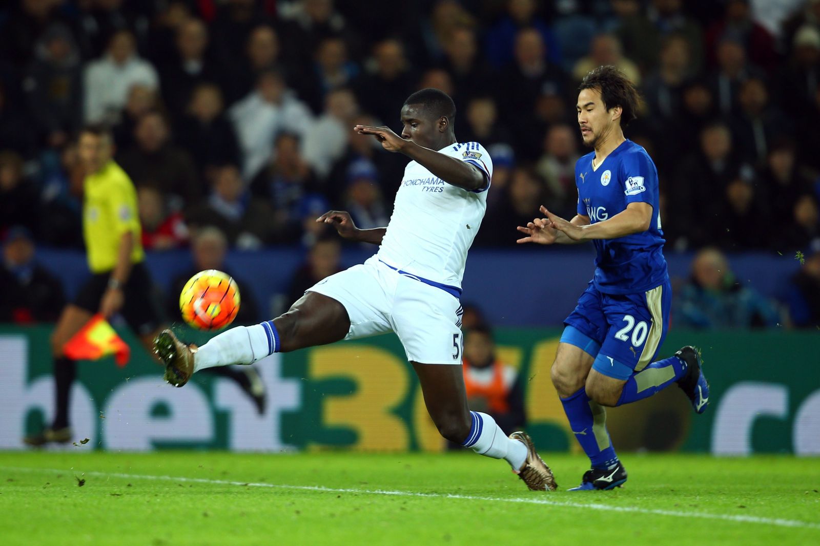 El francés Kurt Zouma despeja el balón ante la presión del jugador del Leicester Okazaki.