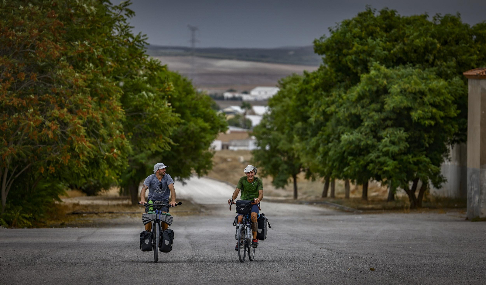 Dos ciclistas atraviesan El Palmar de Troya.