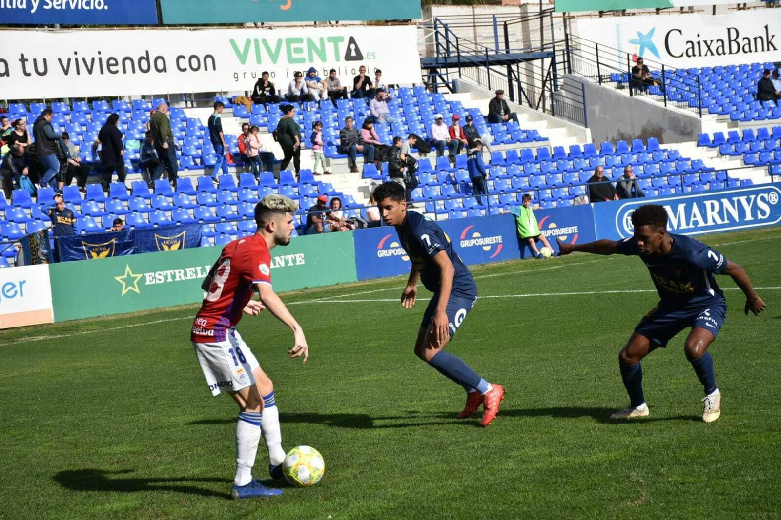 Isi Ros encara a dos jugadores del UCAM durante el encuentro.