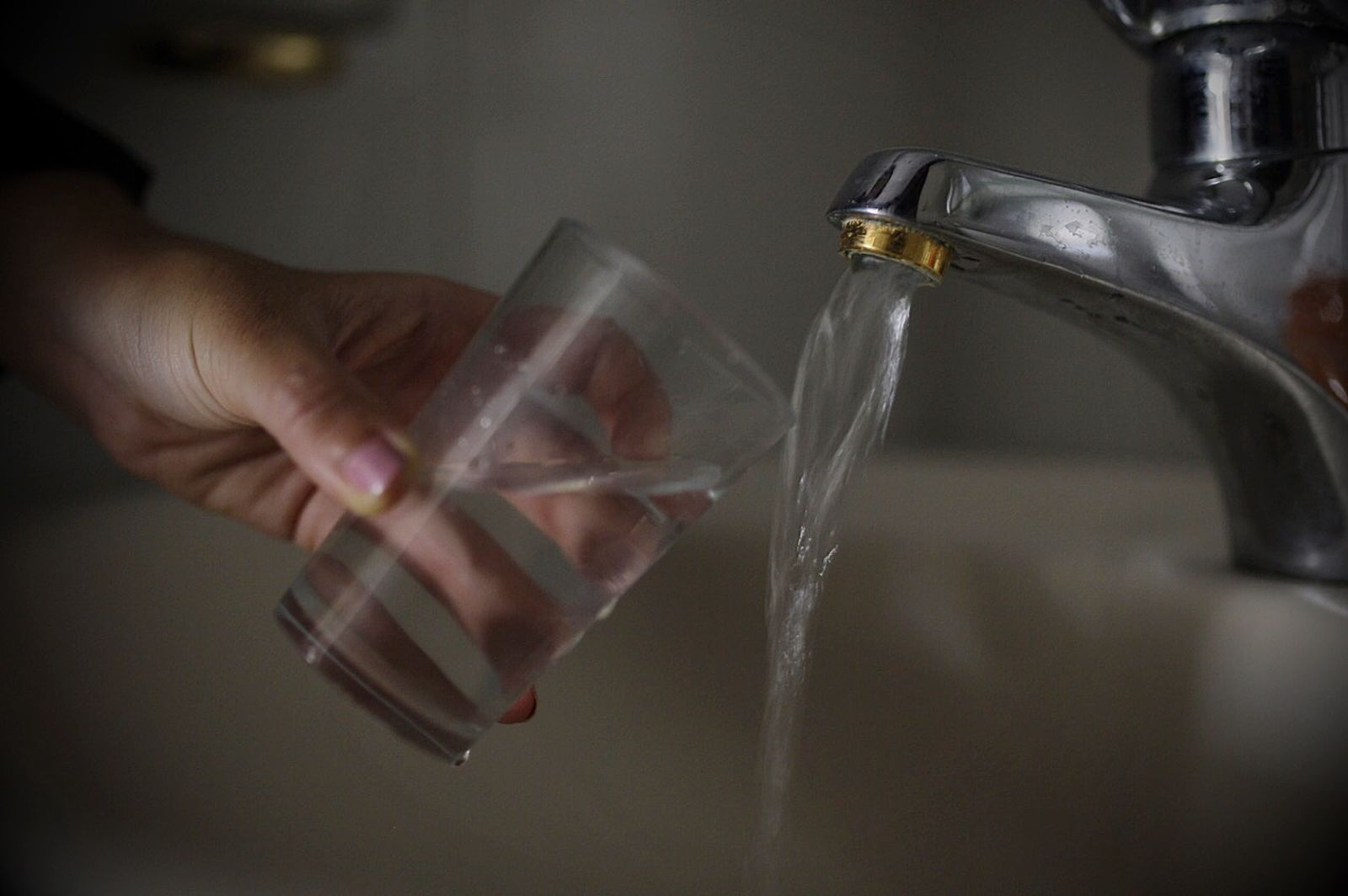 Una vecina llena un vaso de agua de grifo