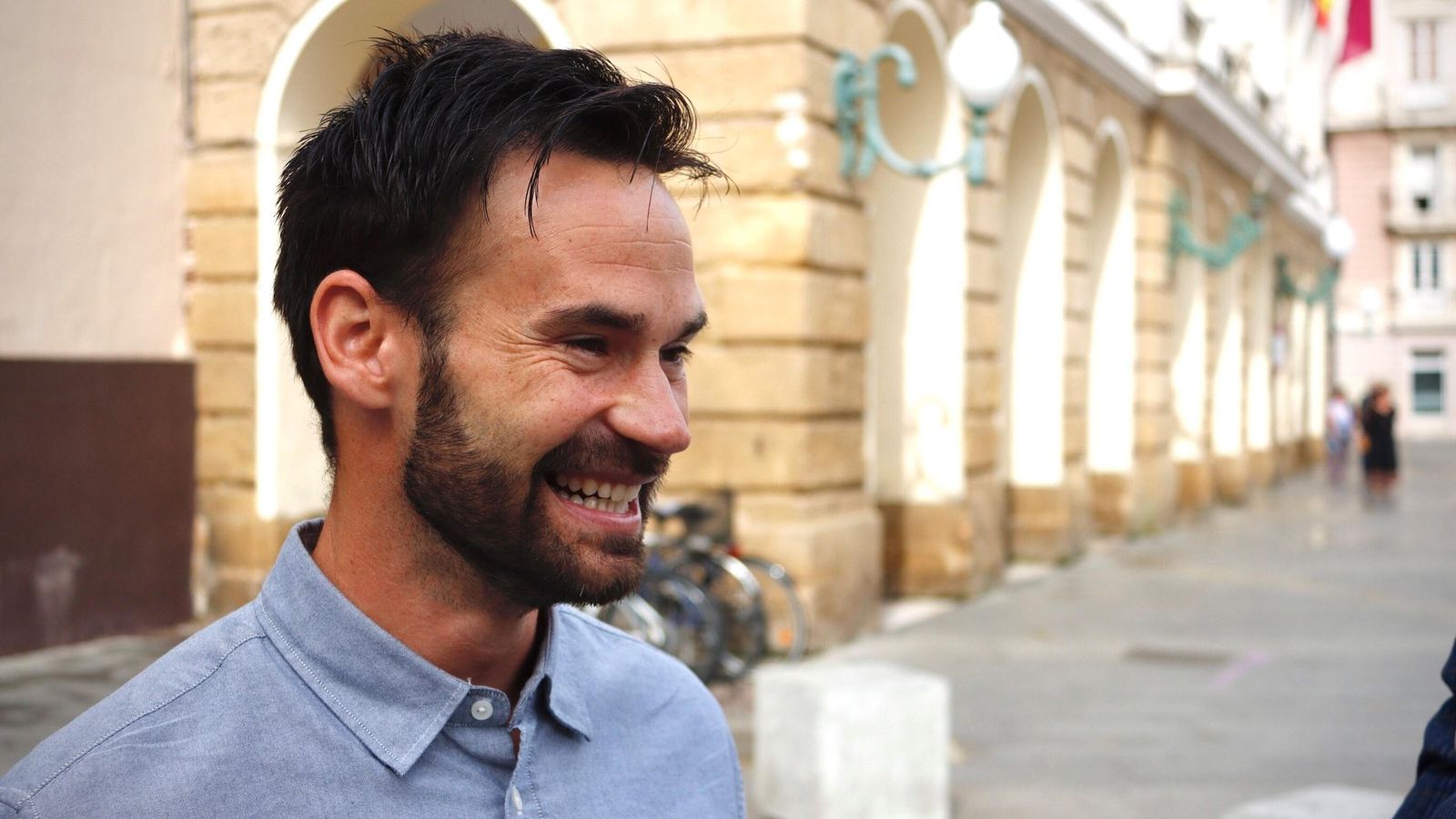 David de la Cruz sonríe con la fachada del Ayuntamiento de Cádiz al fondo.