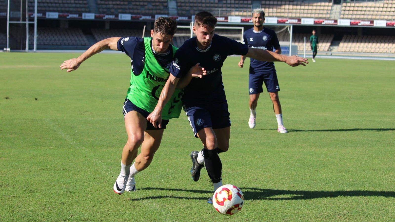 Rafa Parejo conduce el balón en el entrenamiento de este jueves en Chapín perseguido por Álvaro Martínez.