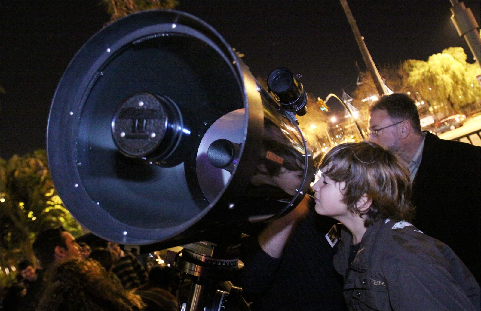 Un niño mira por uno de los telescopios de la SMA en una actividad nocturna.