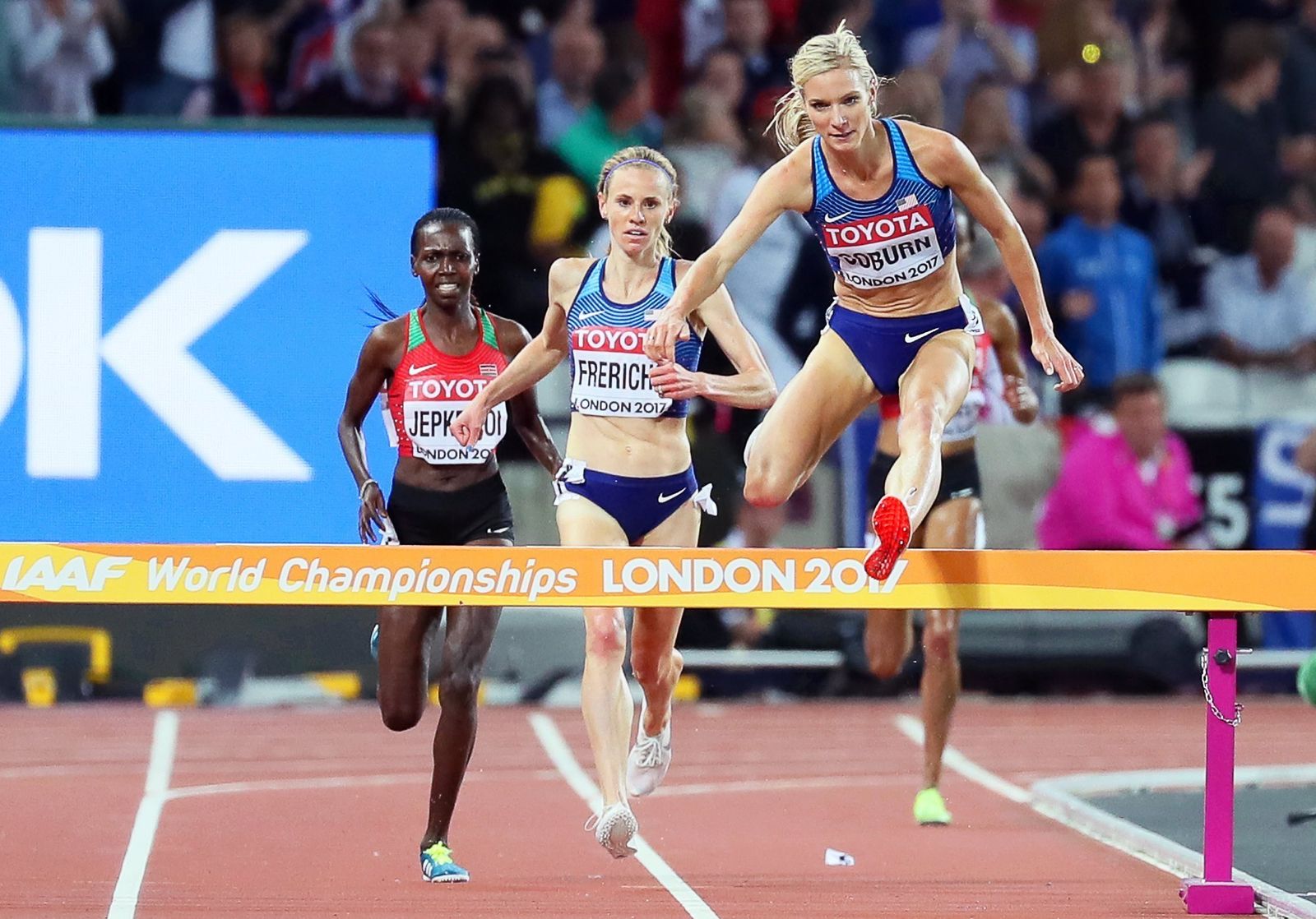 Emma Coburn, campeona del mundo de 3.000 obstáculos, salva una valla de los últimos metros seguida de su compatriota Courtney Frerichs.