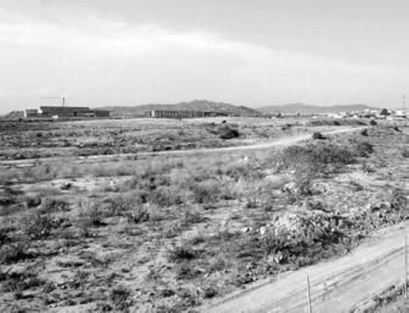 Vista de los suelos de la antigua fábrica de amoniaco y al fondo la ampliación de la Universidad.