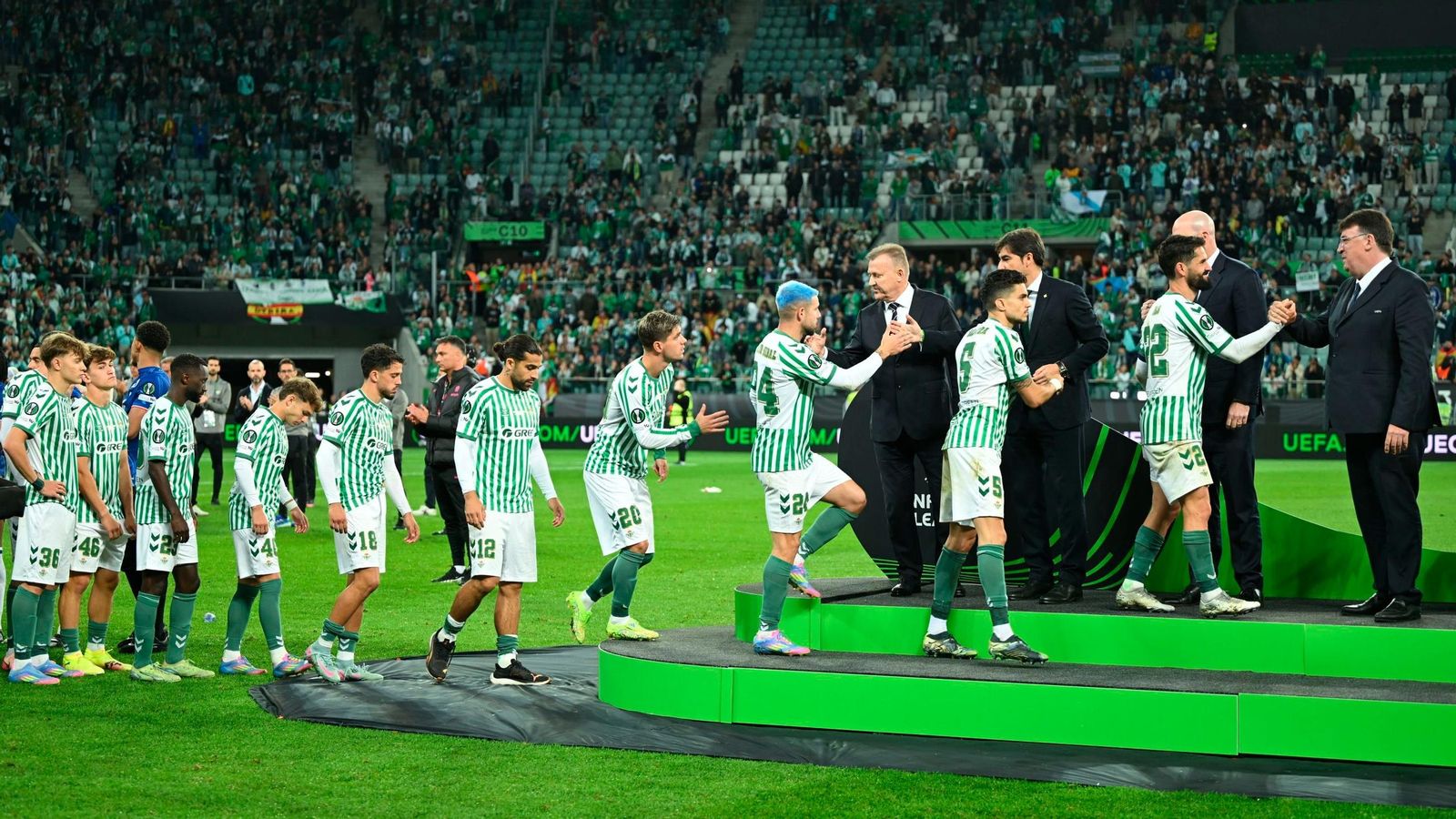 Los jugadores del Betis recogen su medalla como subcampeones de la Conference League.