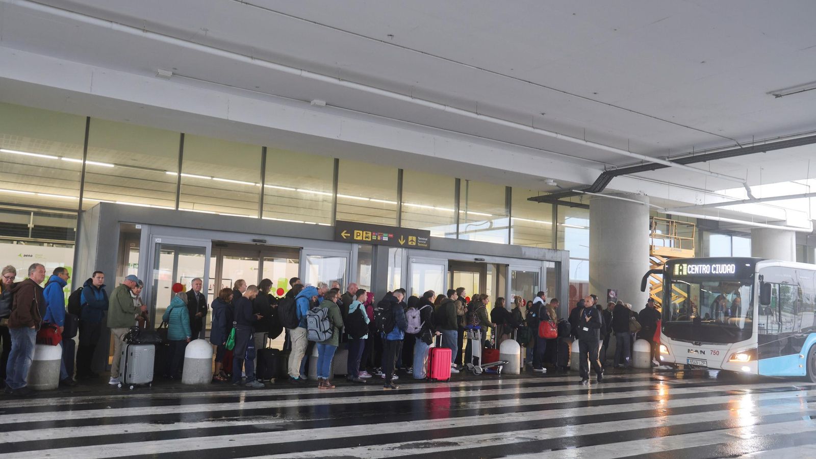 Pasajeros en cola en el aeropuerto para coger un autobús de la EMT. Pasajeros en cola en el aeropuerto para coger un autobús de la EMT.