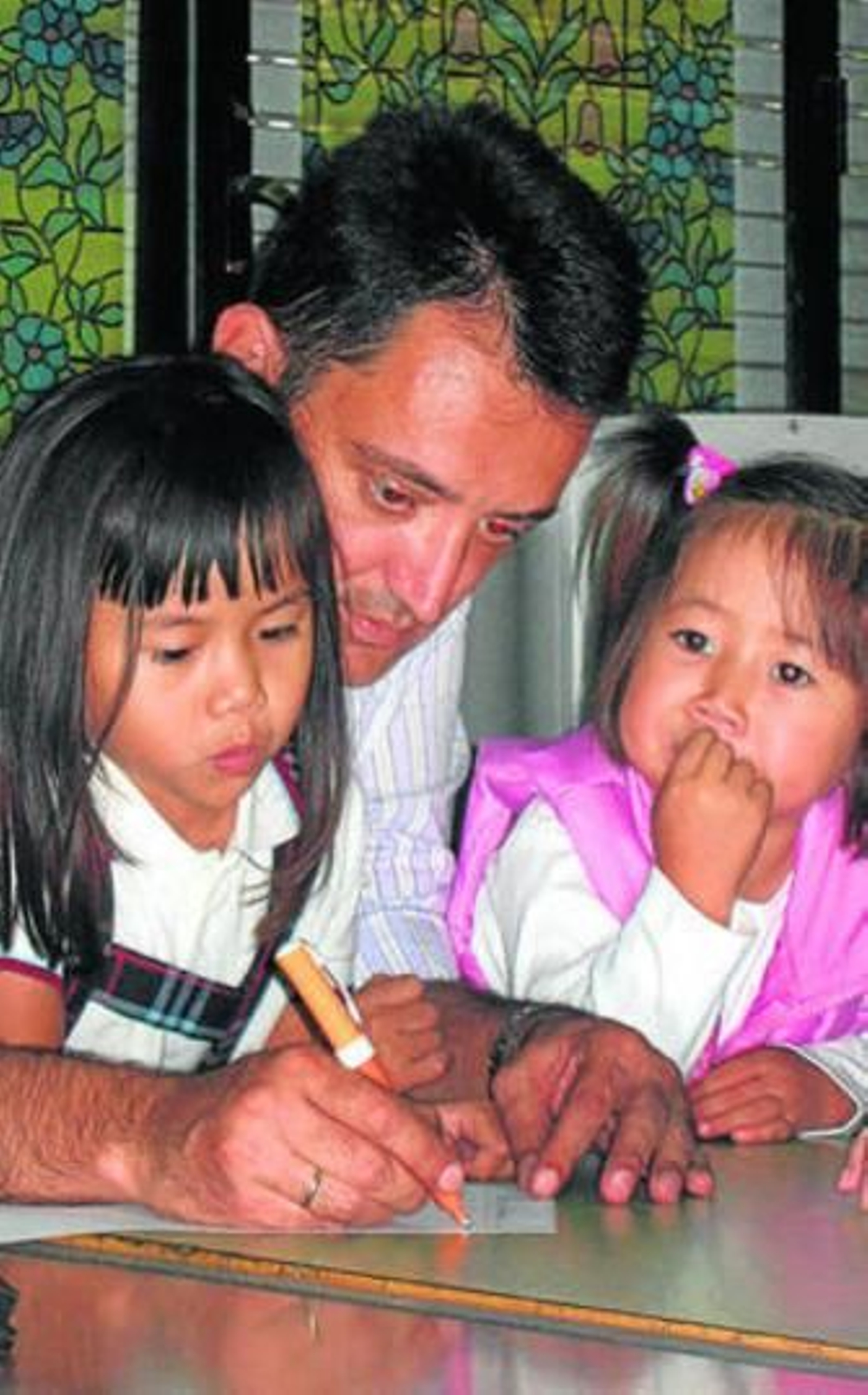 Un padre inscribe a sus dos hijas para estudiar chino.
