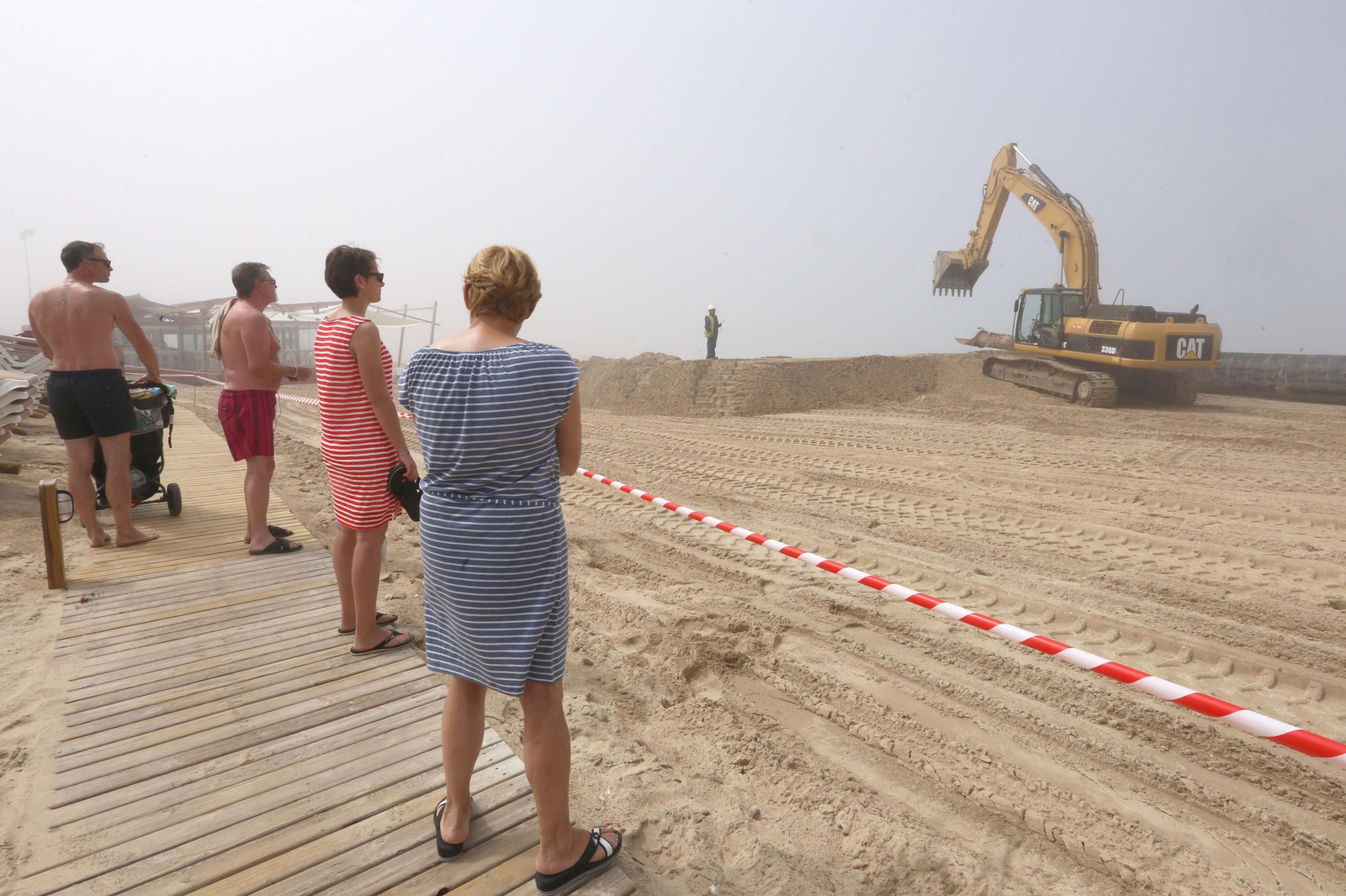 Los bañistas observan los trabajos que se realizaban ayer en la zona de hoteles de Novo Sancti Petri.