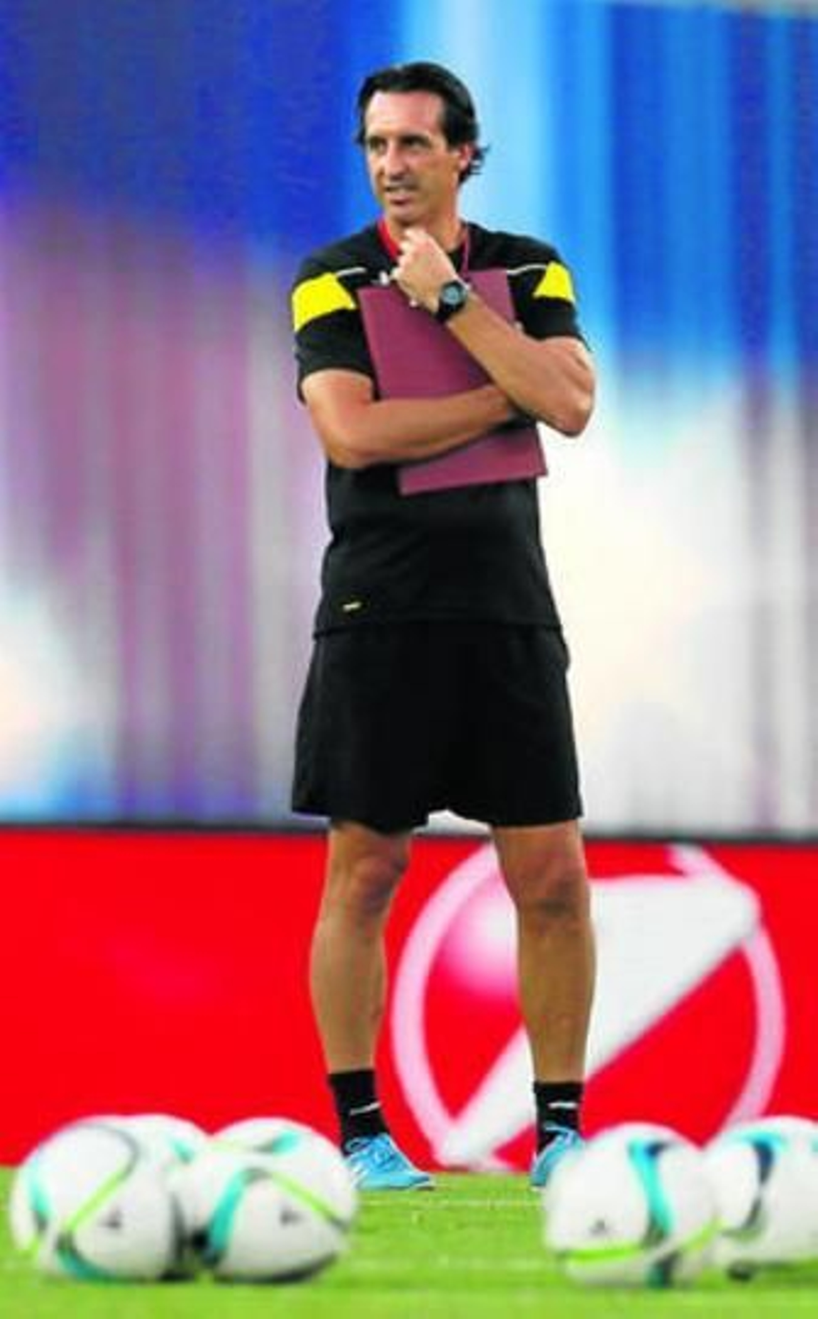 Unai Emery esboza media sonrisa distraída mientras medita durante el entrenamiento.