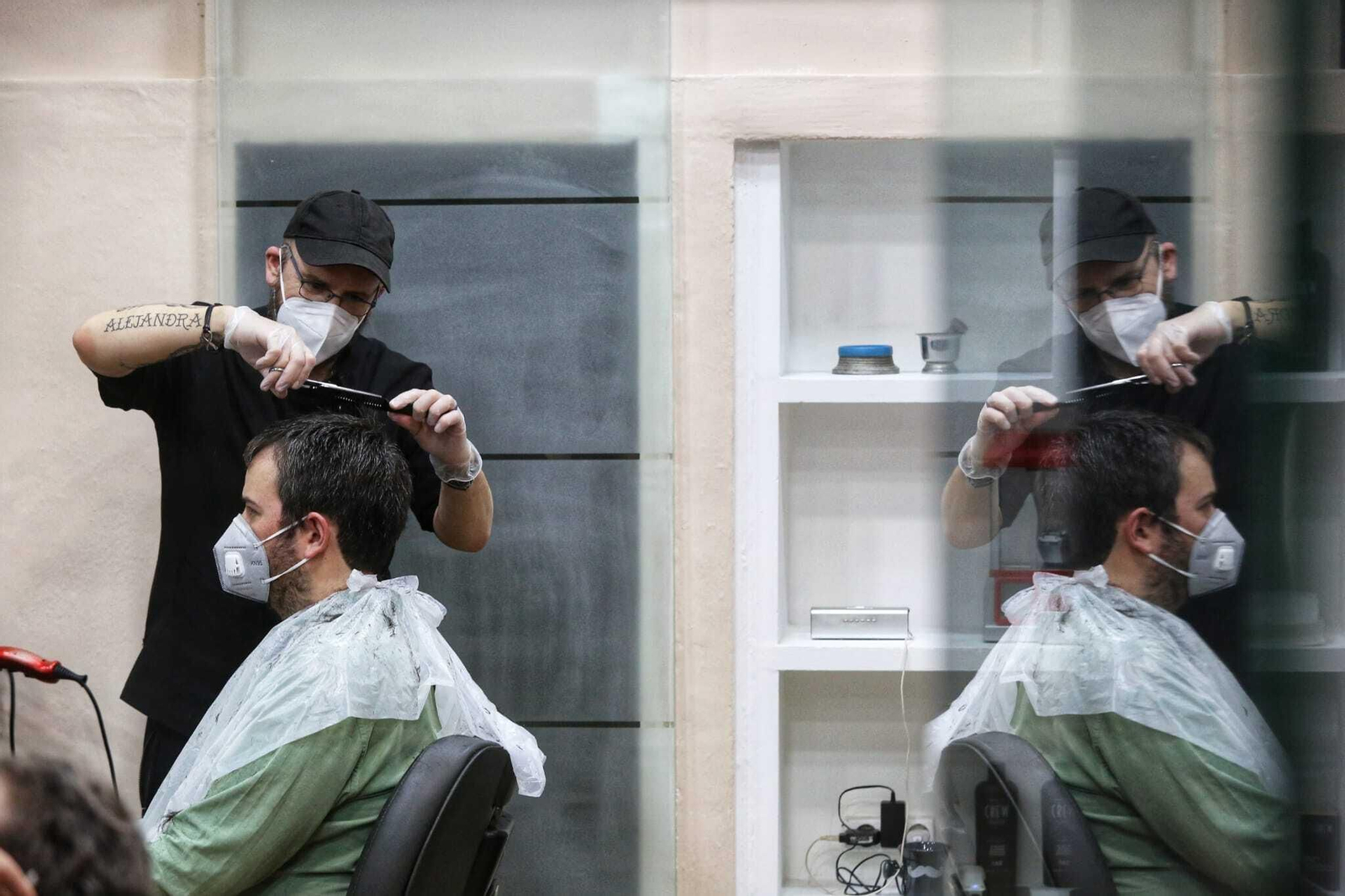 Un peluquero atiende a un cliente este lunes en Málaga