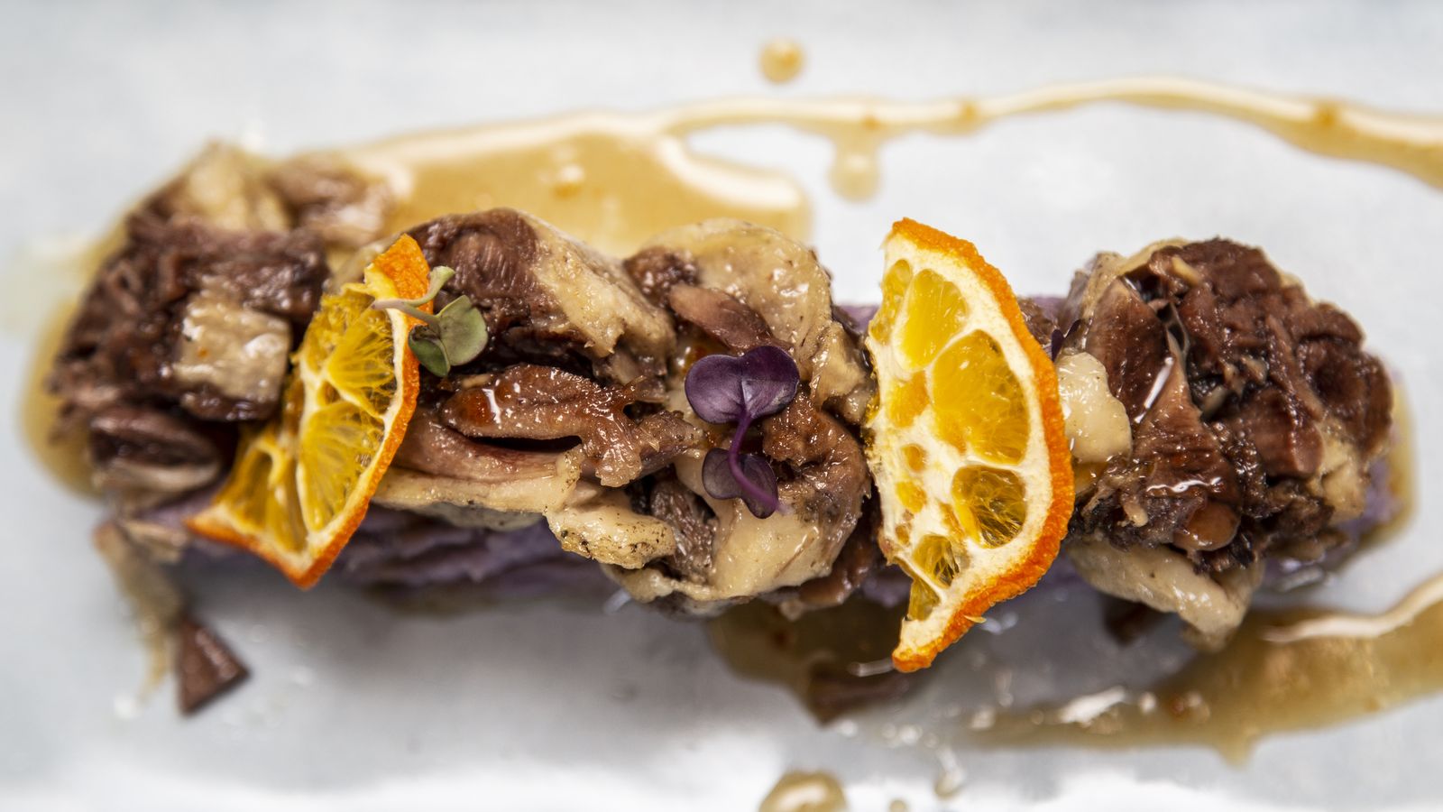 Confit de pato deshuesado a la naranja con cremoso de patatas violeta.